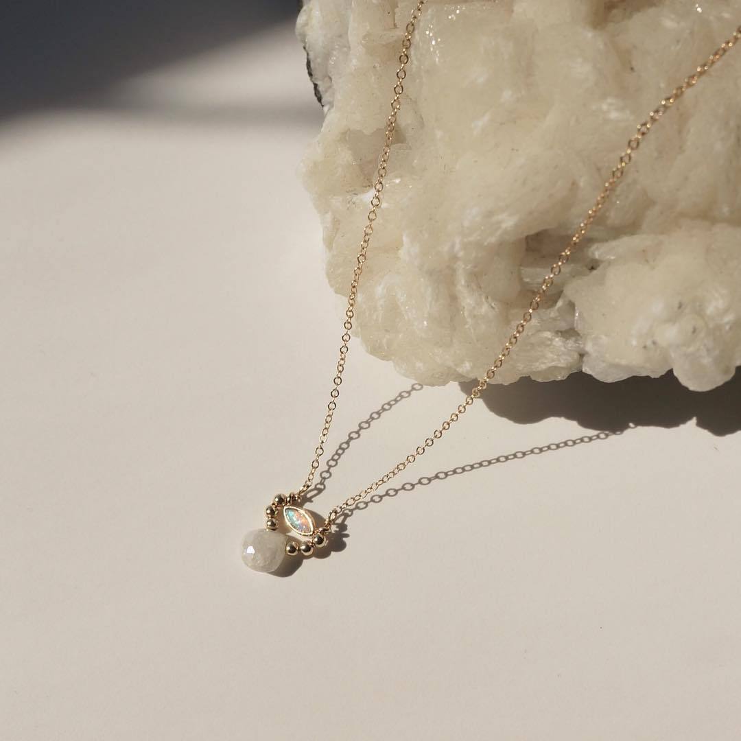 Amara Necklace by KOZAKH. A 16 to 18 inch adjustable length necklace in 14K Gold Filled, featuring a Marquise Opal charm, 2mm Gold Filled balls, and a faceted Silverite.