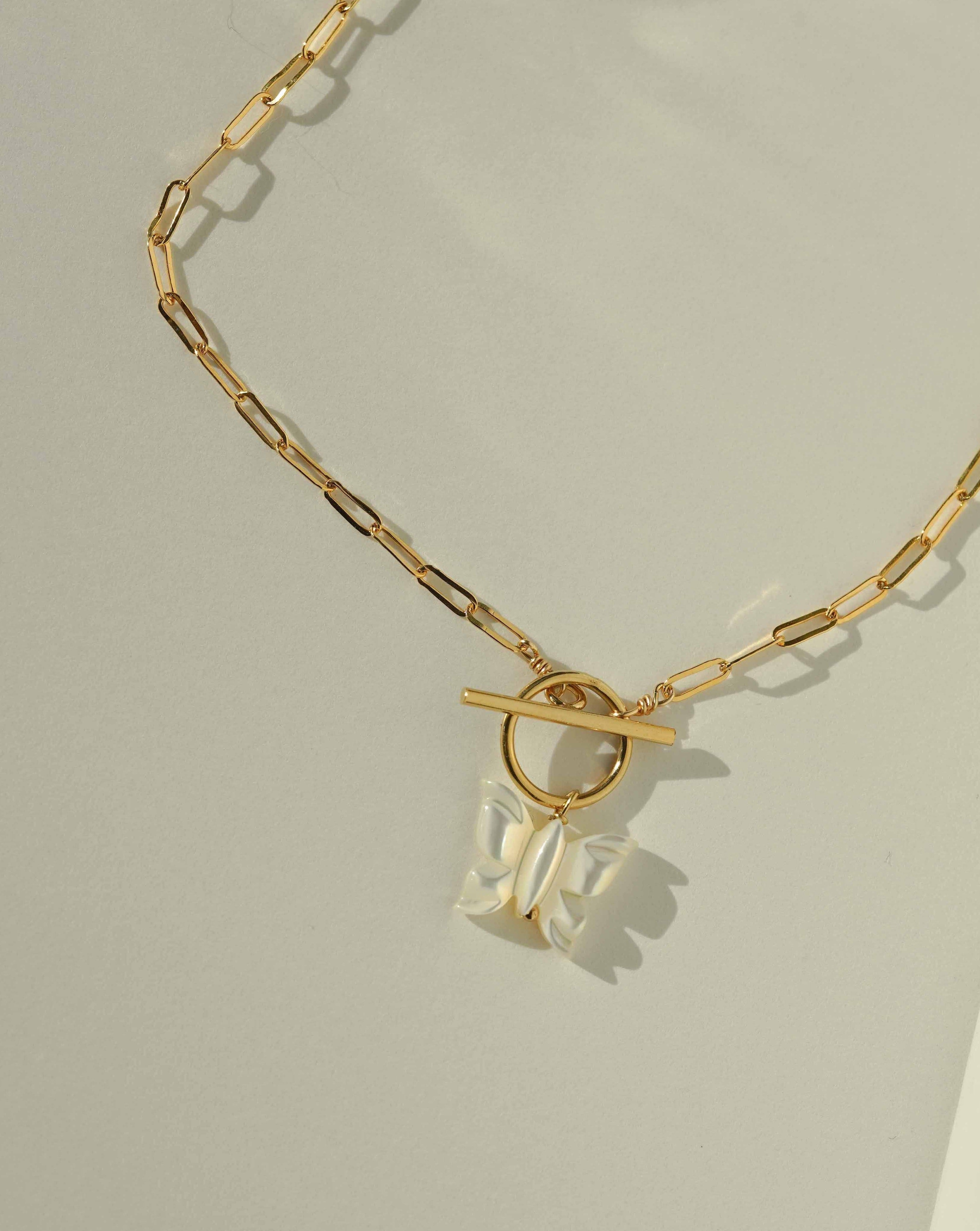 Arlette Necklace by KOZAKH. A 16 to 18 inch adjustable length necklace in 14K Gold Filled, featuring a hand-carved Mother of Pearl butterfly charm and a toggle closure at front of the necklace.