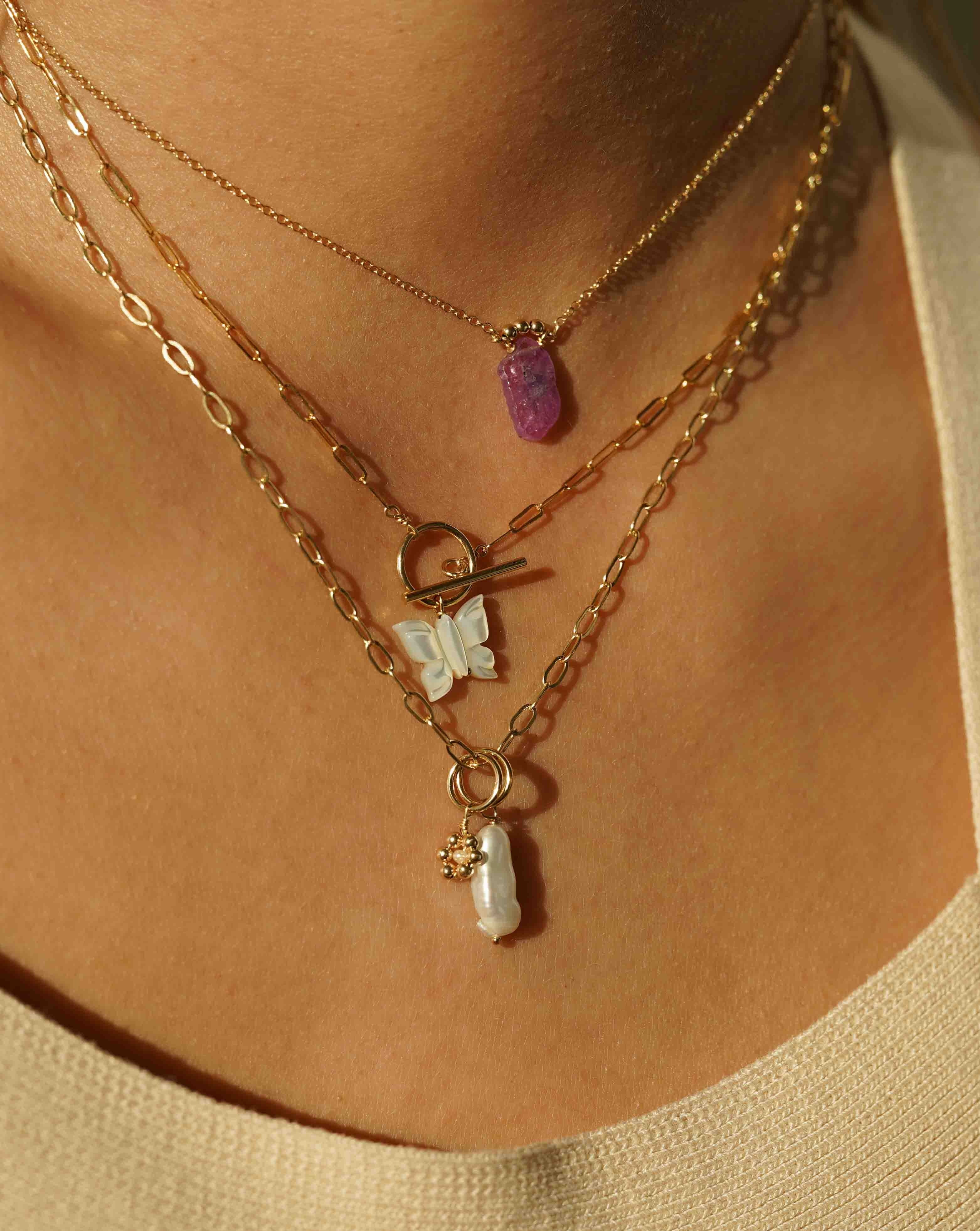 Arlette Necklace by KOZAKH. A 16 to 18 inch adjustable length necklace in 14K Gold Filled, featuring a hand-carved Mother of Pearl butterfly charm and a toggle closure at front of the necklace.