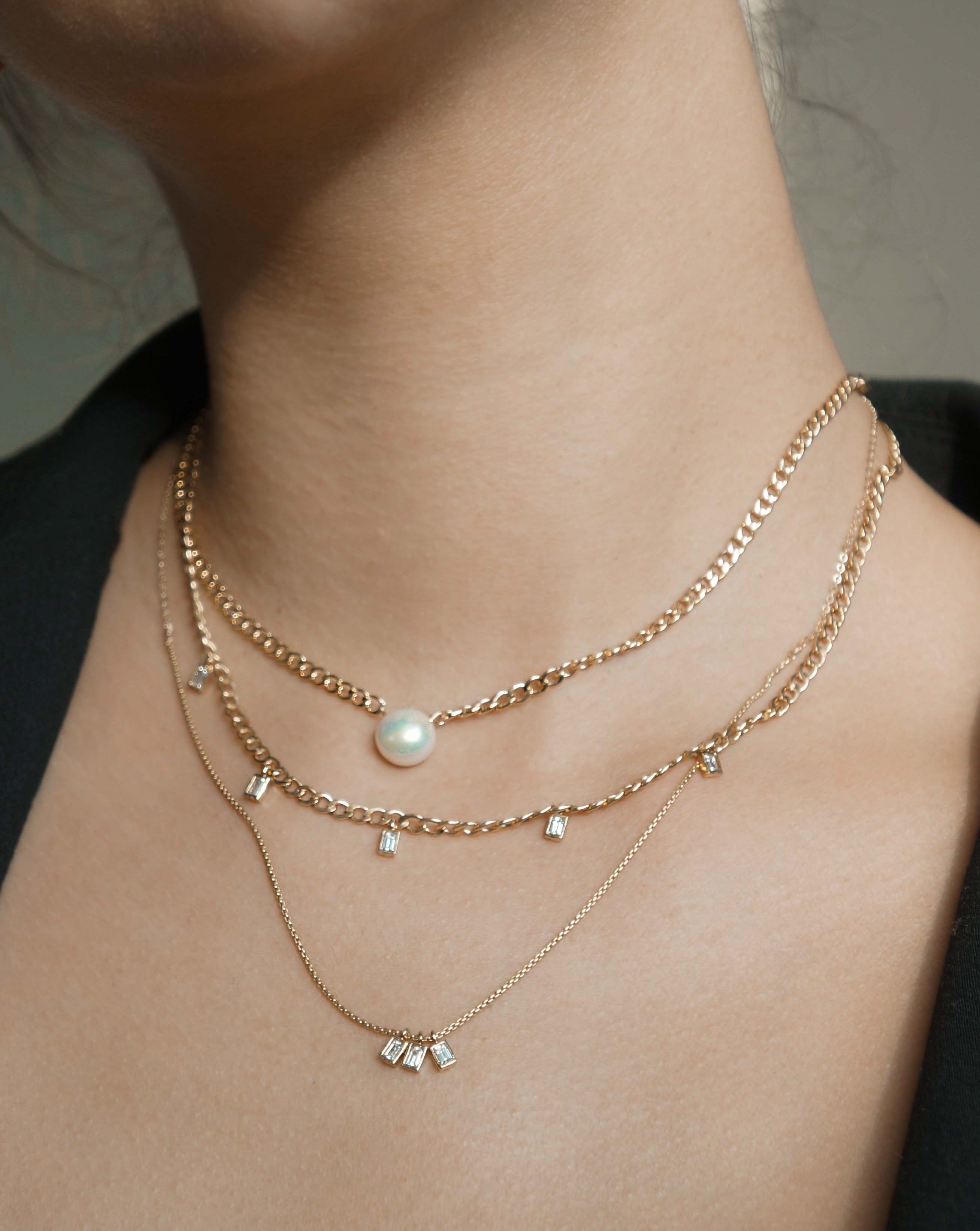 Avery Necklace by KOZAKH. A 16 to 18 inch adjustable length necklace in 14K Gold Filled, featuring 3 square cut Cubic Zirconias.