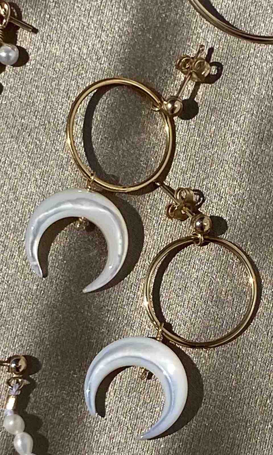 Baques Earrings by KOZAKH. Dangling earrings in 14K Gold Filled, featuring a hand-carved Mother of Pearl moon charm.