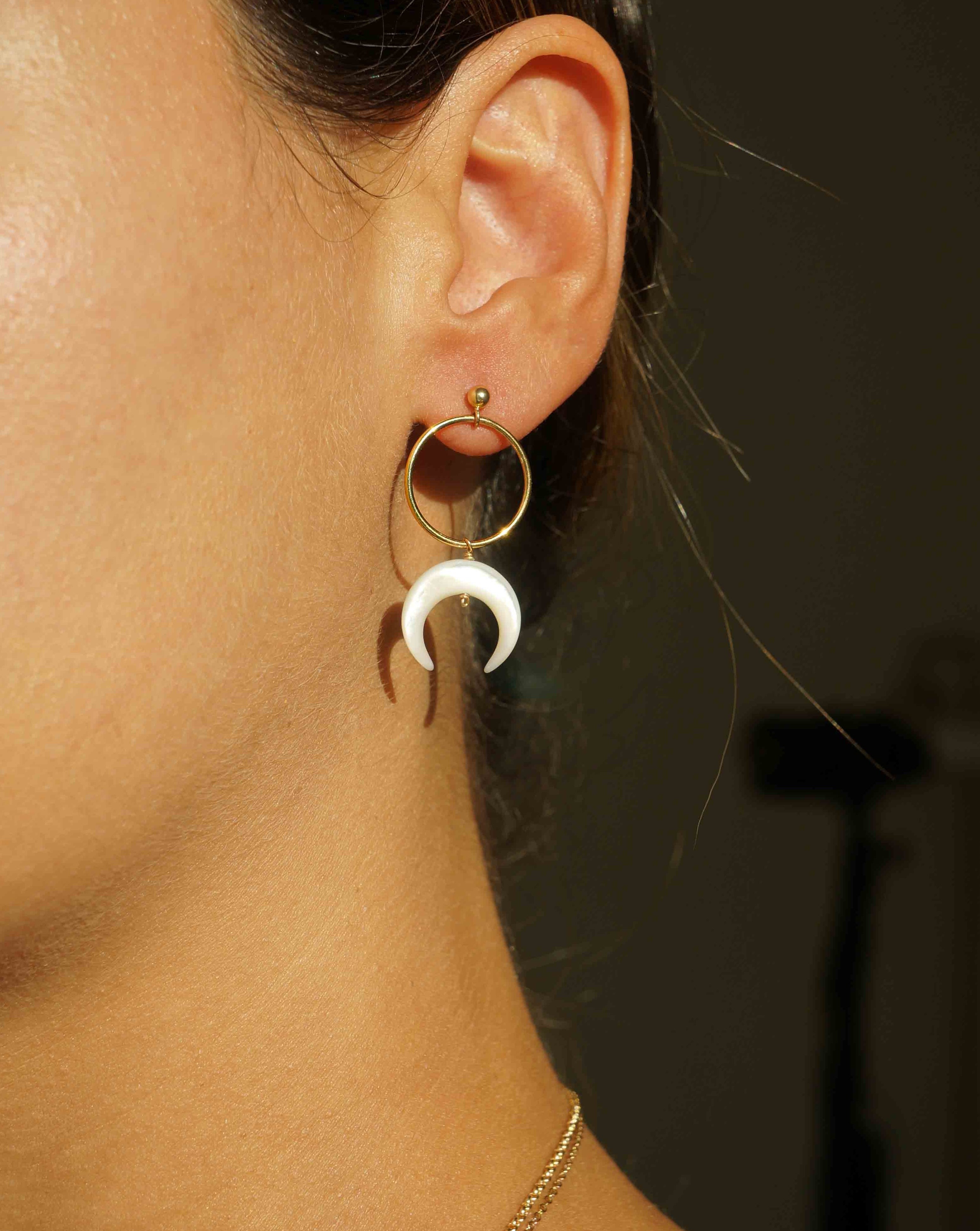 Baques Earrings by KOZAKH. Dangling earrings in 14K Gold Filled, featuring a hand-carved Mother of Pearl moon charm.