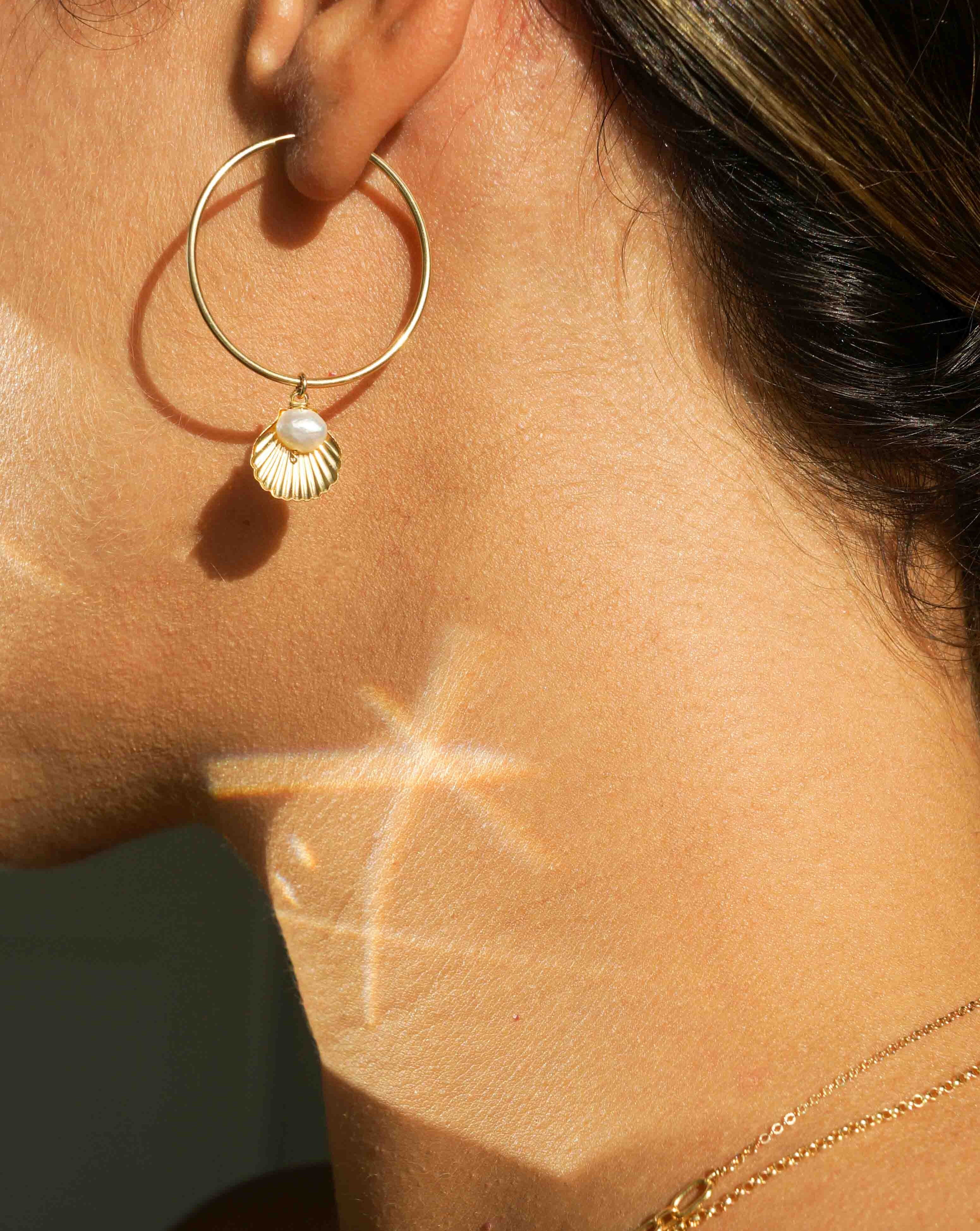 Belle Hoop Earrings by KOZAKH. A 30mm hoop earrings in 14K Gold Filled, featuring a 5mm flat irregular Pearl and a Shell charm.