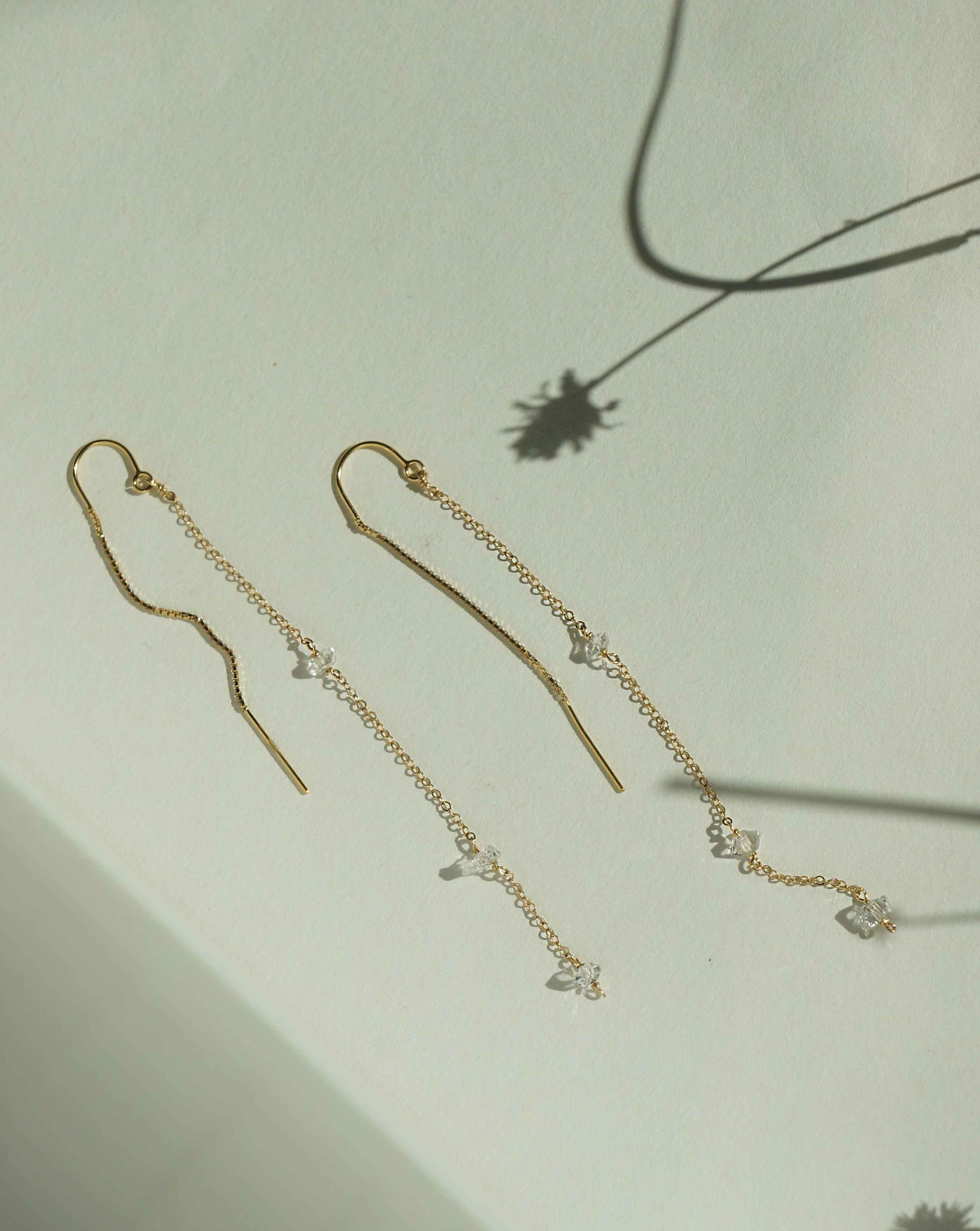 Chatoyant Threader Earrings by KOZAKH. 2 1/2 inch drop threader earrings in 14K Gold Filled, featuring Herkimer Diamonds.