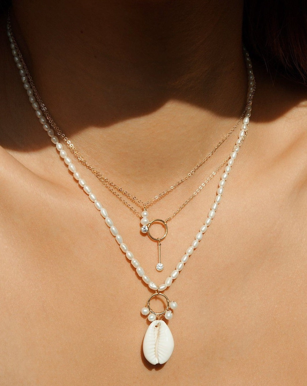 Coco Necklace by KOZAKH. A 16 to 18 inch adjustable length necklace in 14K Gold Filled, featuring 4mm to 5mm white round Pearls and a 3mm Cubic Zirconia bezel.