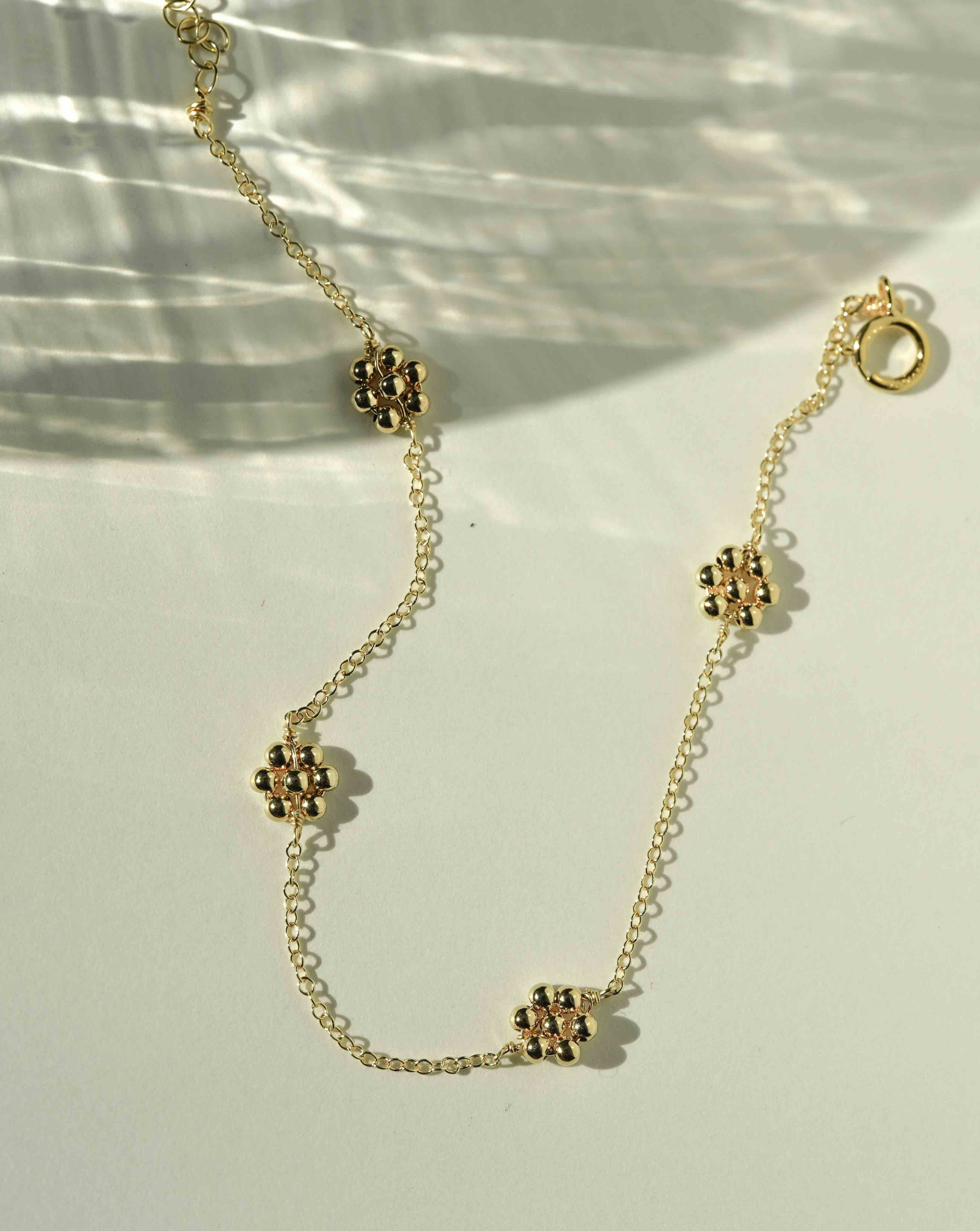 Davina Bracelet by KOZAKH. A 6 to 7 inch adjustable length bracelet, crafted in 14K Gold Filled, featuring handmade gold beaded daisies.
