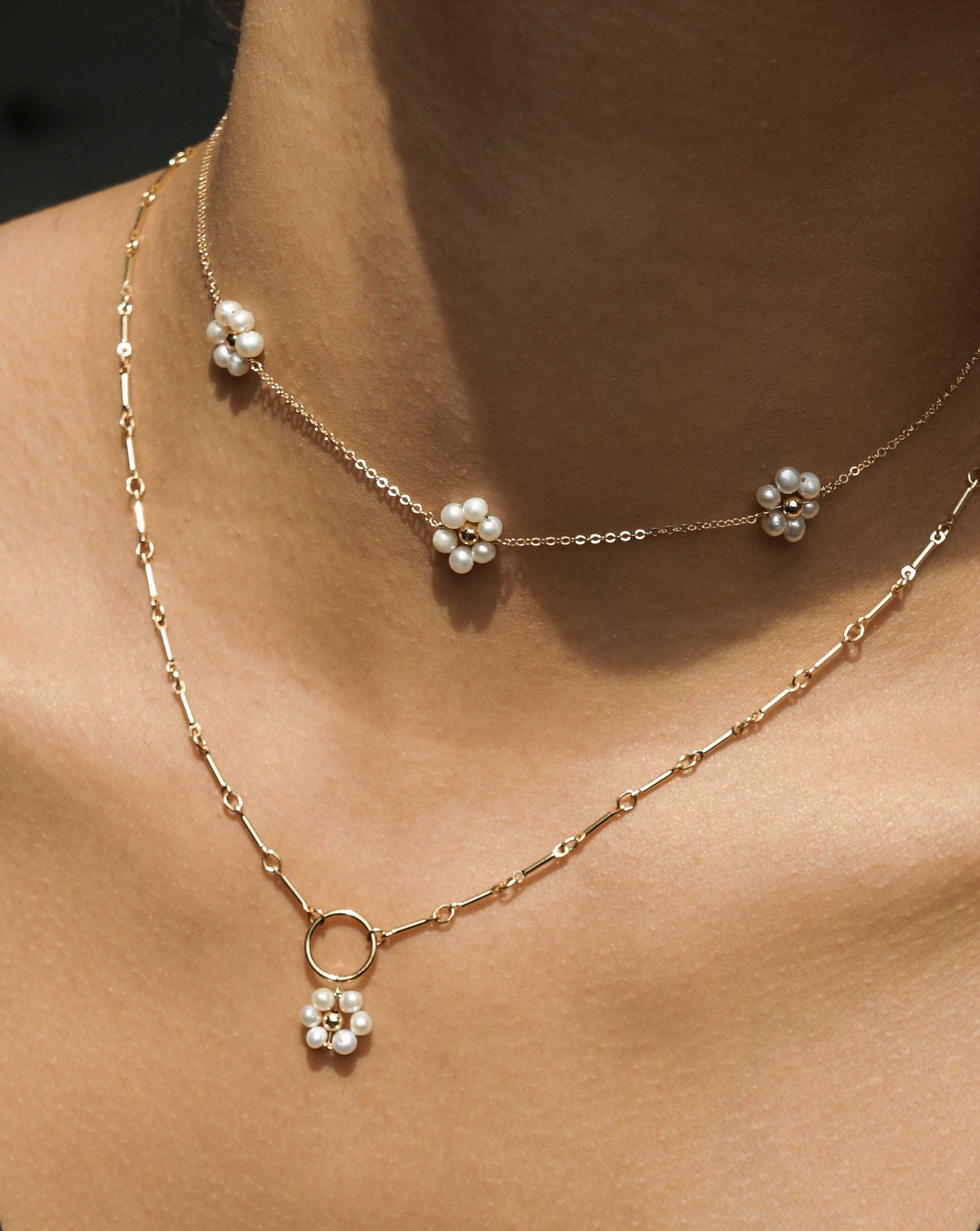 Flor Del Sol Necklace by KOZAKH. A 16 to 18 inch adjustable length necklace in 14K Gold Filled, featuring 3mm Freshwater Pearls in form of a daisy.