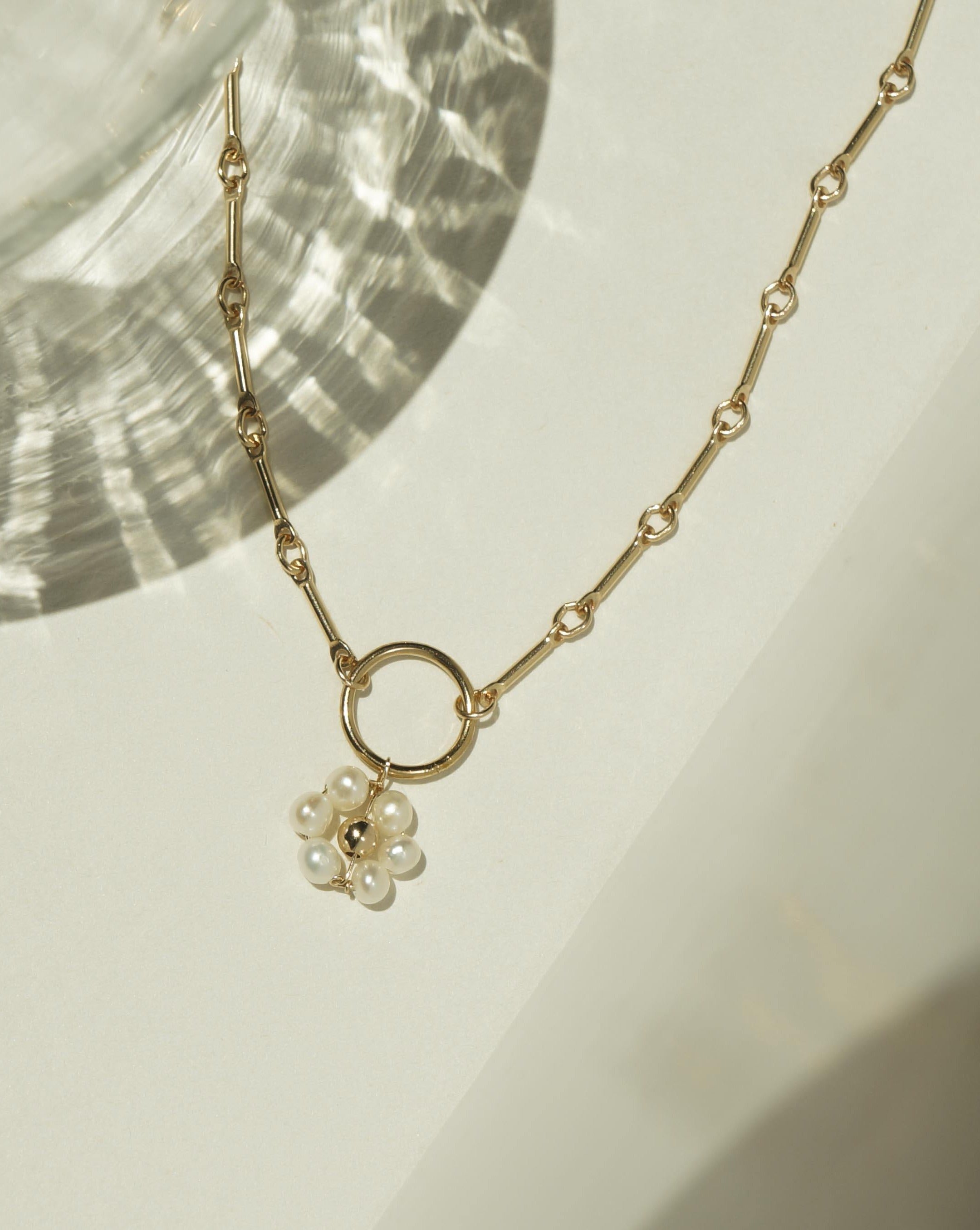 Flor Del Sol Necklace by KOZAKH. A 16 to 18 inch adjustable length necklace in 14K Gold Filled, featuring 3mm Freshwater Pearls in form of a daisy.