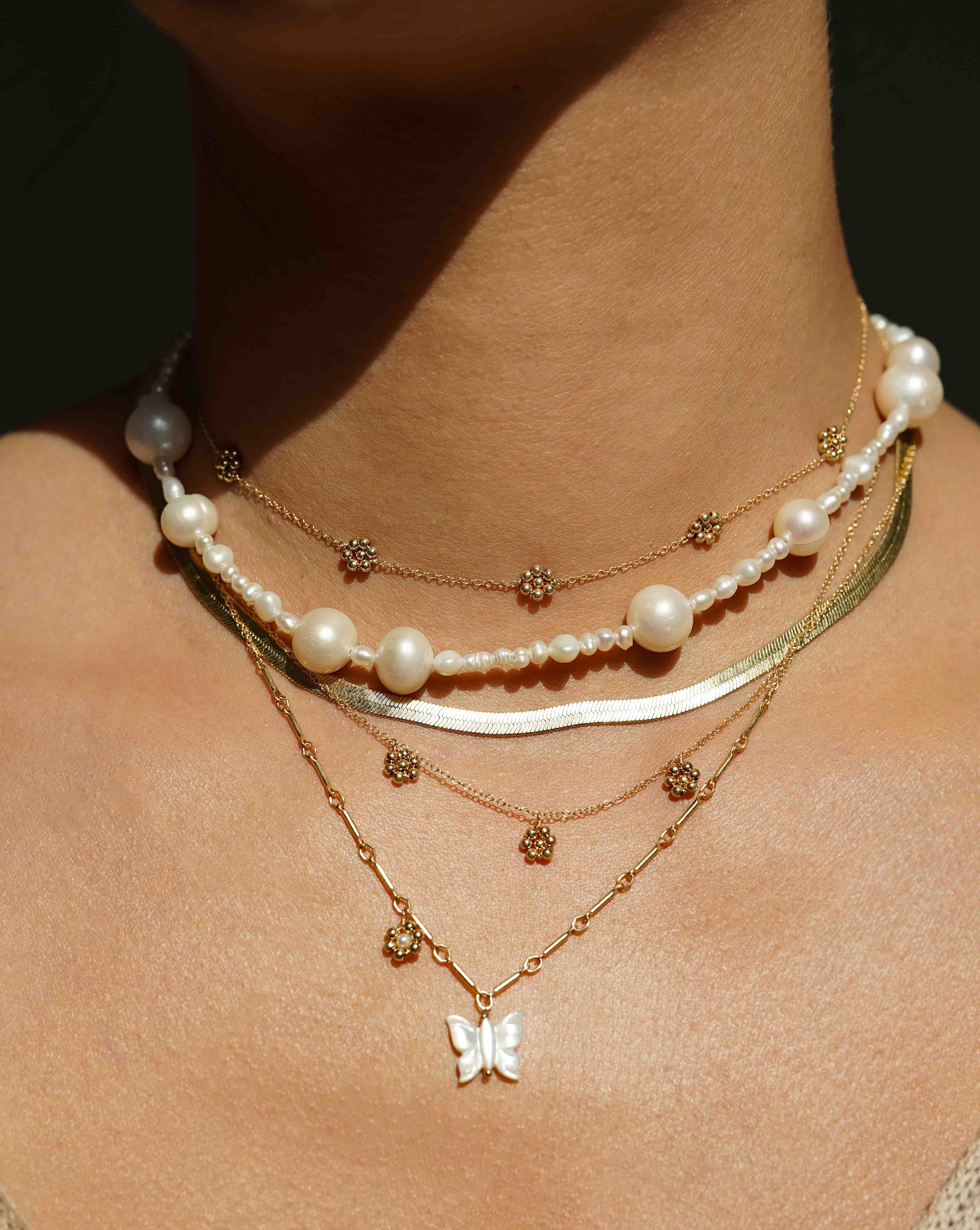 Flora Necklace by KOZAKH. A 16 to 18 inch adjustable length necklace in 14K Gold Filled, featuring handmade gold beaded daisies.