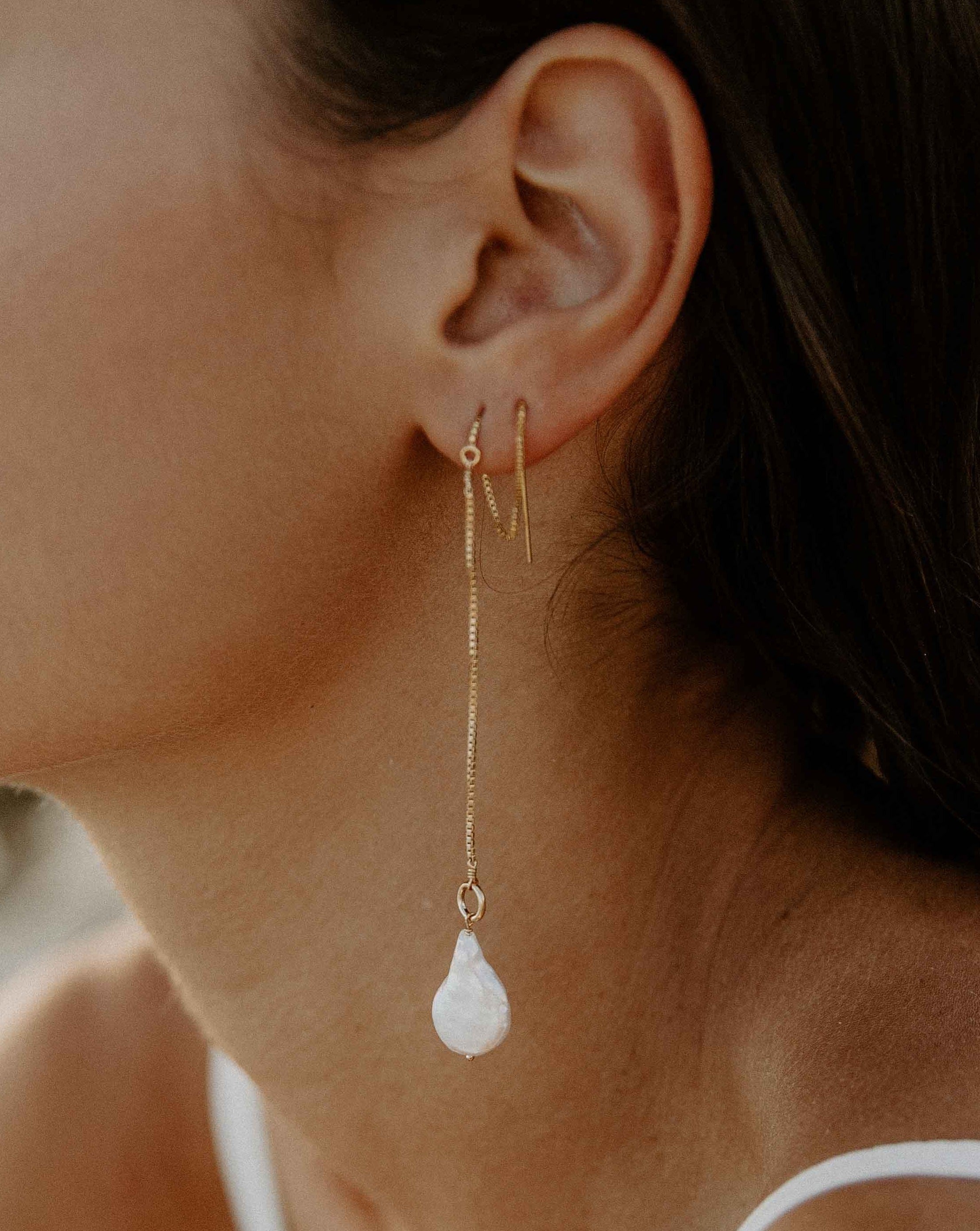 Genesis Threaders by KOZAKH. Threader style earrings with drop length of 2 inches on both sides, crafted in 14K Gold Filled, featuring Baroque Pearls.