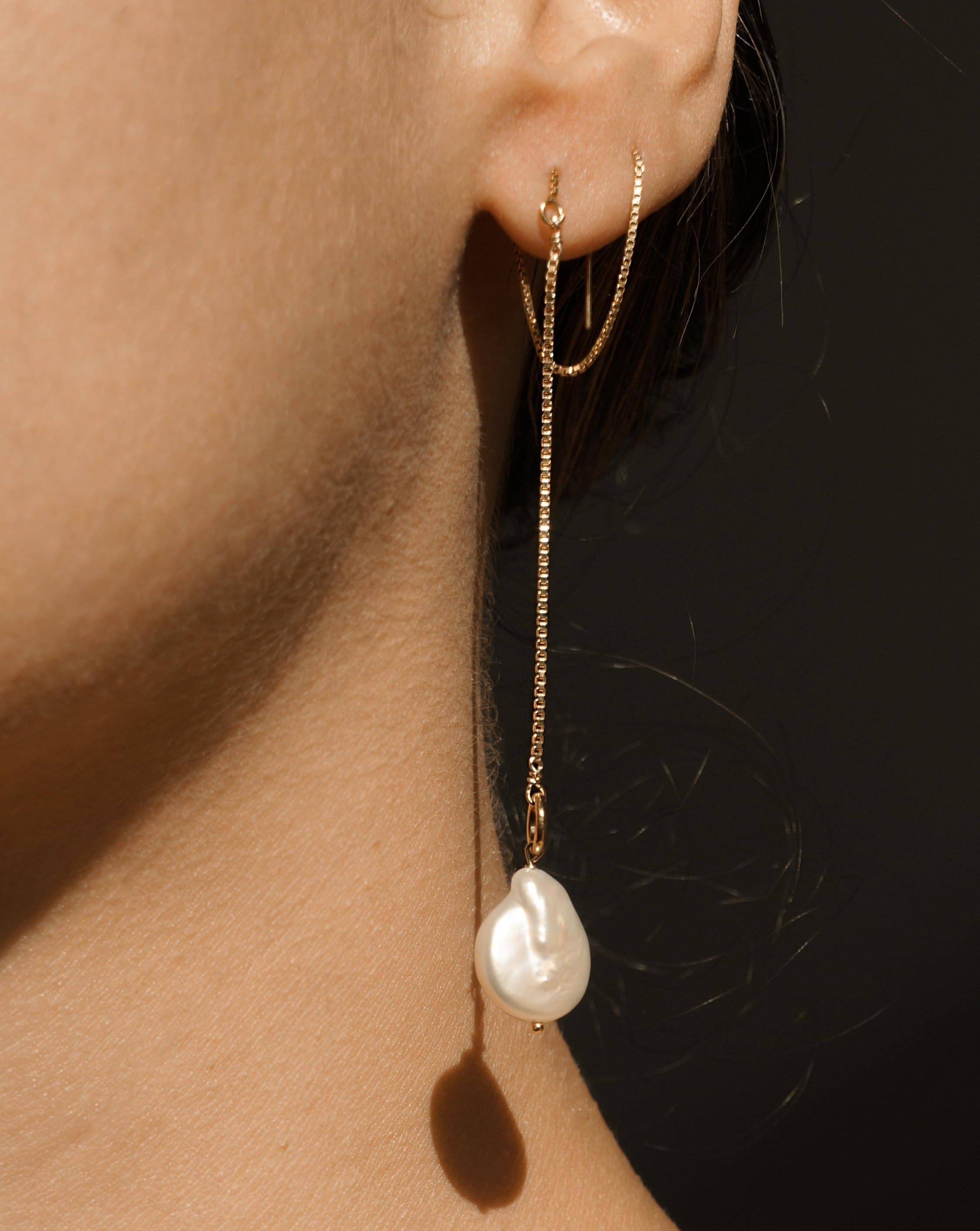 Genesis Threaders by KOZAKH. Threader style earrings with drop length of 2 inches on both sides, crafted in 14K Gold Filled, featuring Baroque Pearls.