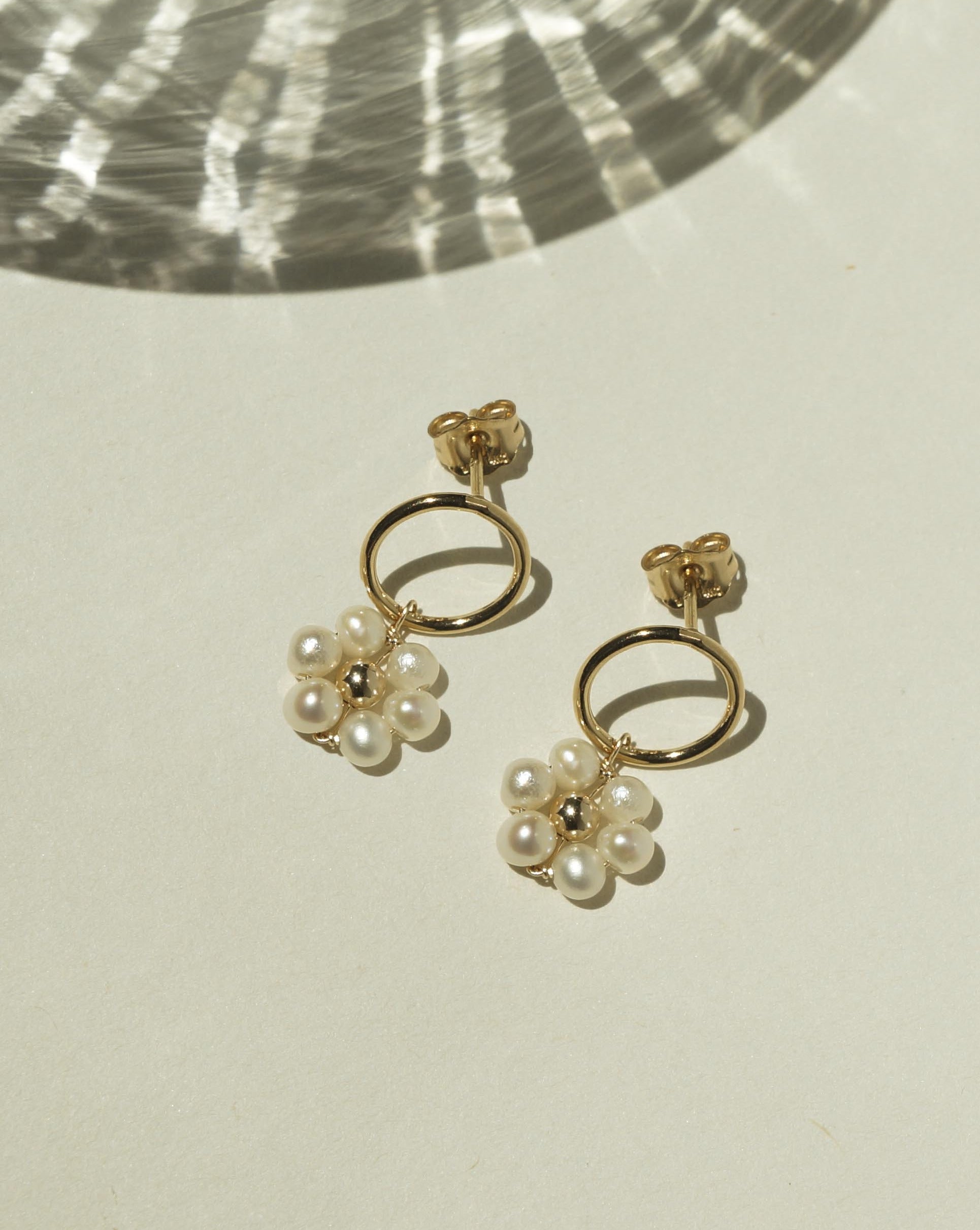 Girasol Earrings by KOZAKH. 10mm circle studs, crafted in 14K Gold Filled, featuring 3-4mm round freshwater Pearls forming a daisy.