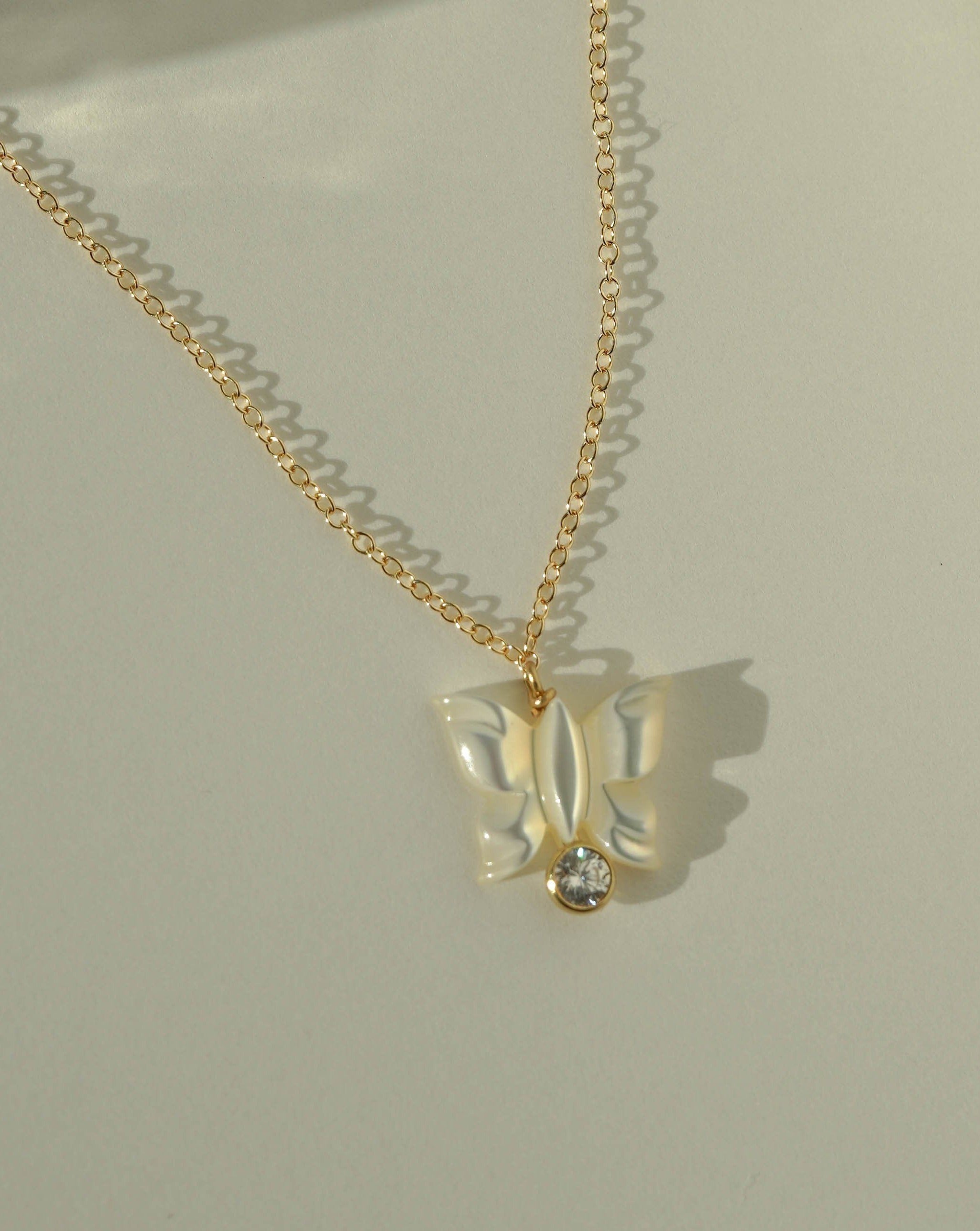 Halo Necklace by KOZAKH. A 16 to 18 inch adjustable length necklace in 14K Gold Filled, featuring a hand-carved Mother of Pearl butterfly charm and a 3mm Cubic Zirconia bezel.
