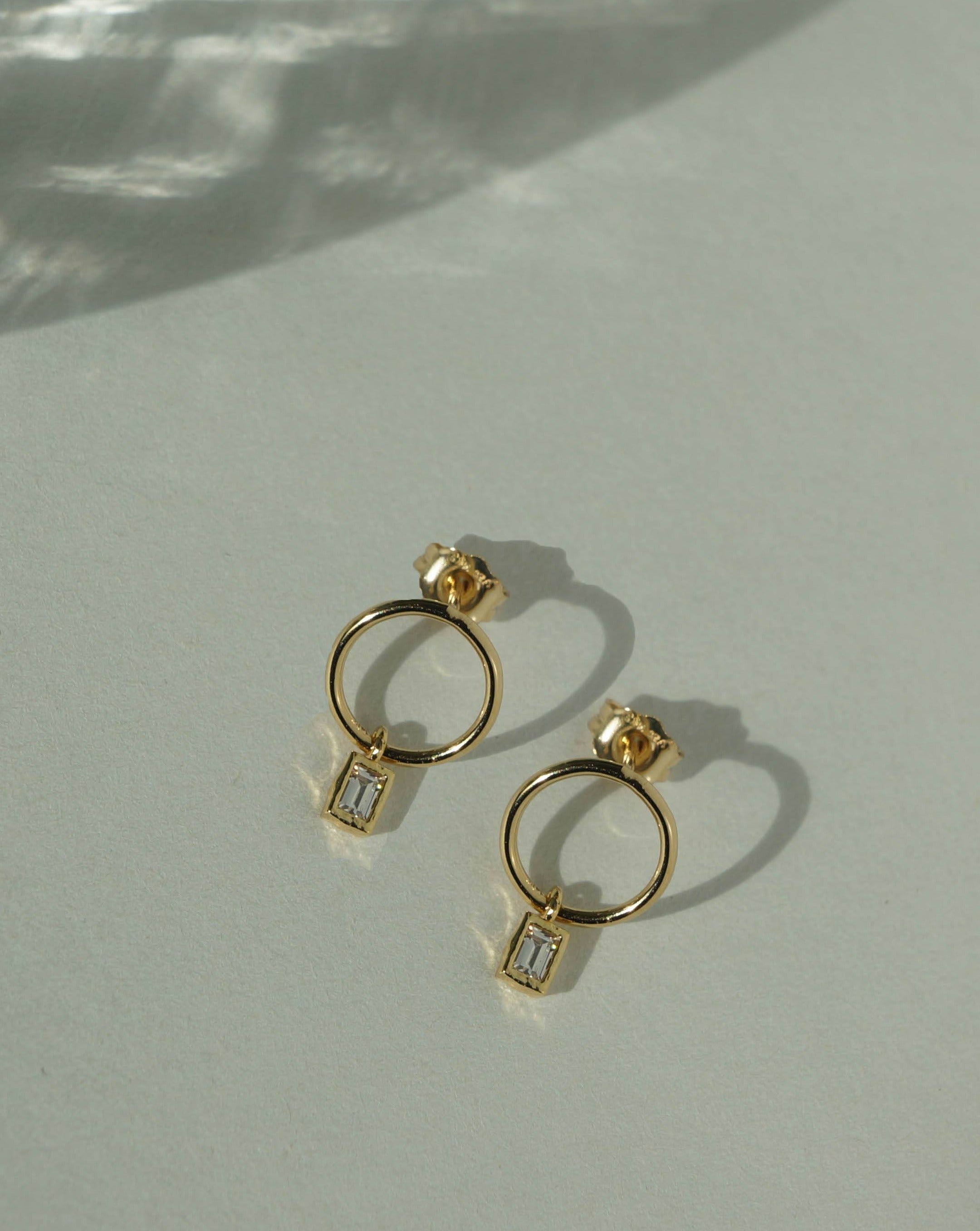 Hannah Earrings by KOZAKH. Mini hoop stud earrings with dangly square cut Cubic Zirconia, crafted in 14K Gold Filled.