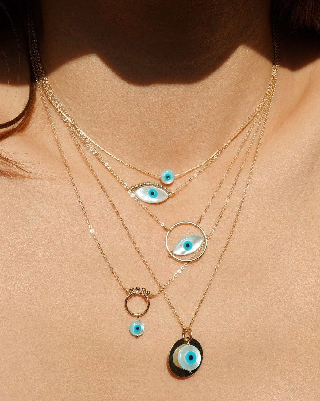 Idra Necklace by KOZAKH. A 16 to 18 inch adjustable length, 1mm thick cordette chain necklace in 14K Gold Filled, featuring a 5mm hand carved Mother of Pearl Evil Eye charm.