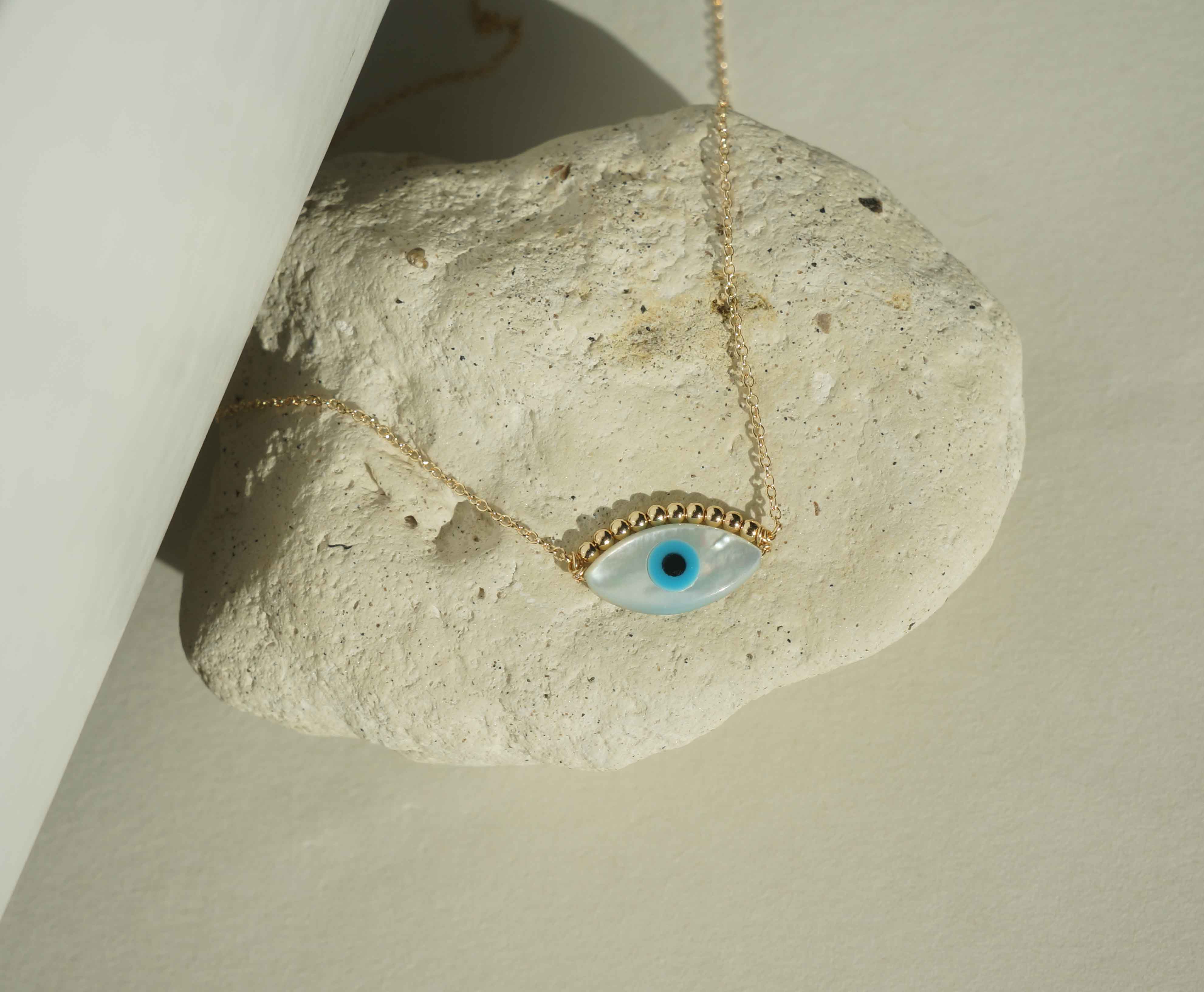 Ira Necklace by KOZAKH. A 16 to 18 inch adjustable length necklace in 14K Gold Filled, featuring a hand carved Mother of Pearl Evil Eye charm and 2mm Seamless gold beads.