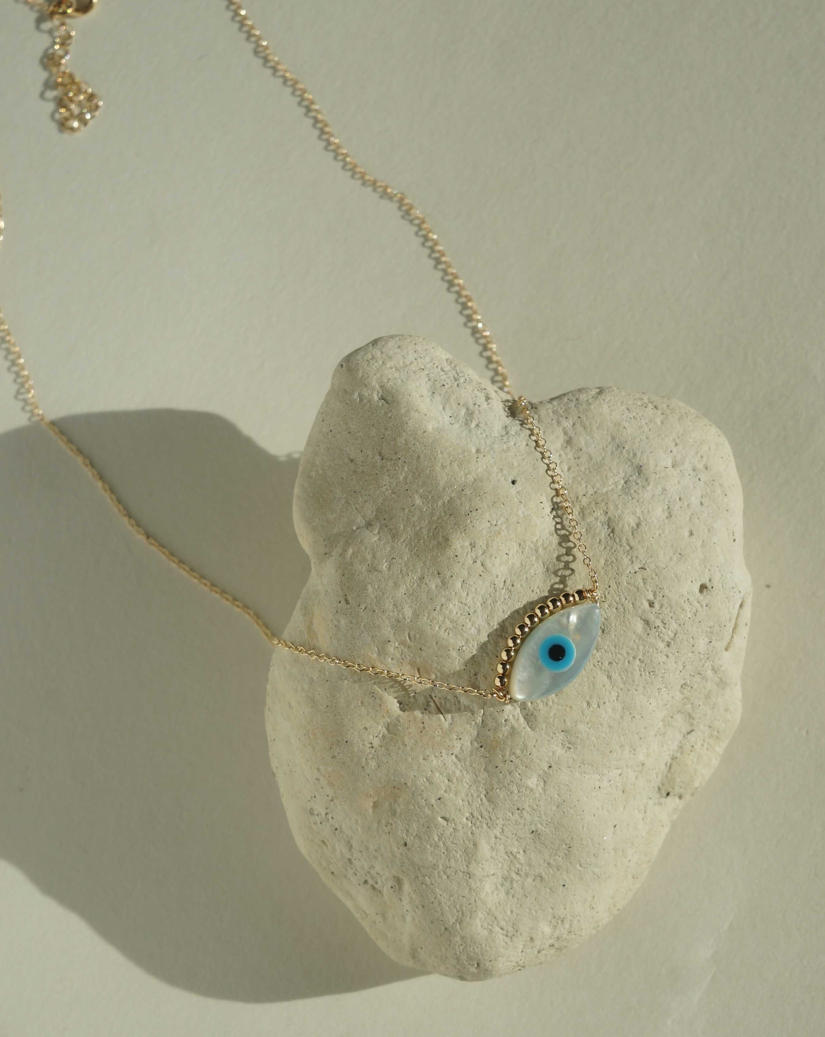 Ira Necklace by KOZAKH. A 16 to 18 inch adjustable length necklace in 14K Gold Filled, featuring a hand carved Mother of Pearl Evil Eye charm and 2mm Seamless gold beads.