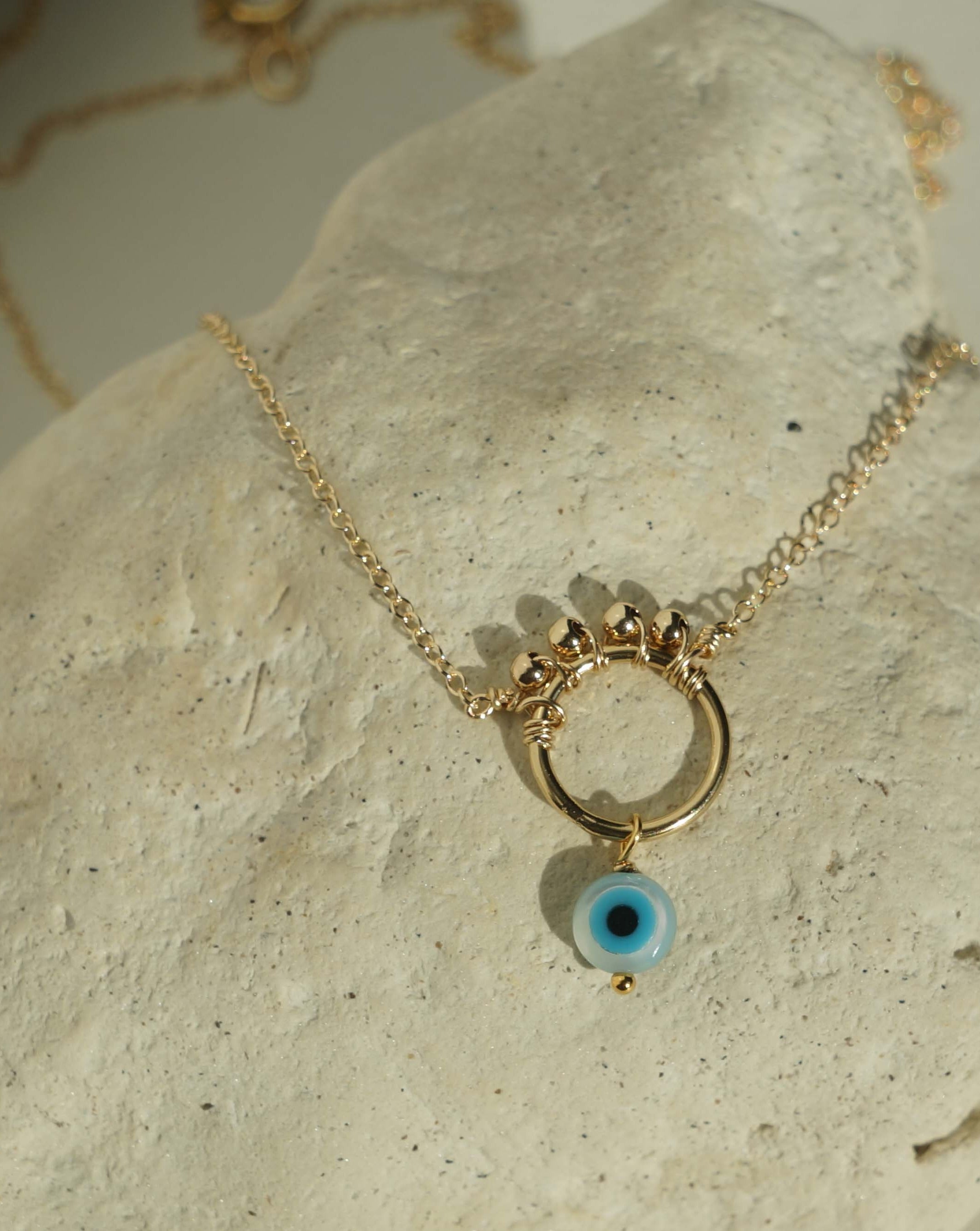 Ivy Necklace by KOZAKH. A 16 to 18 inch adjustable length necklace in 14K Gold Filled, featuring a hand carved Mother of Pearl Evil Eye charm and 2mm Seamless gold beads.