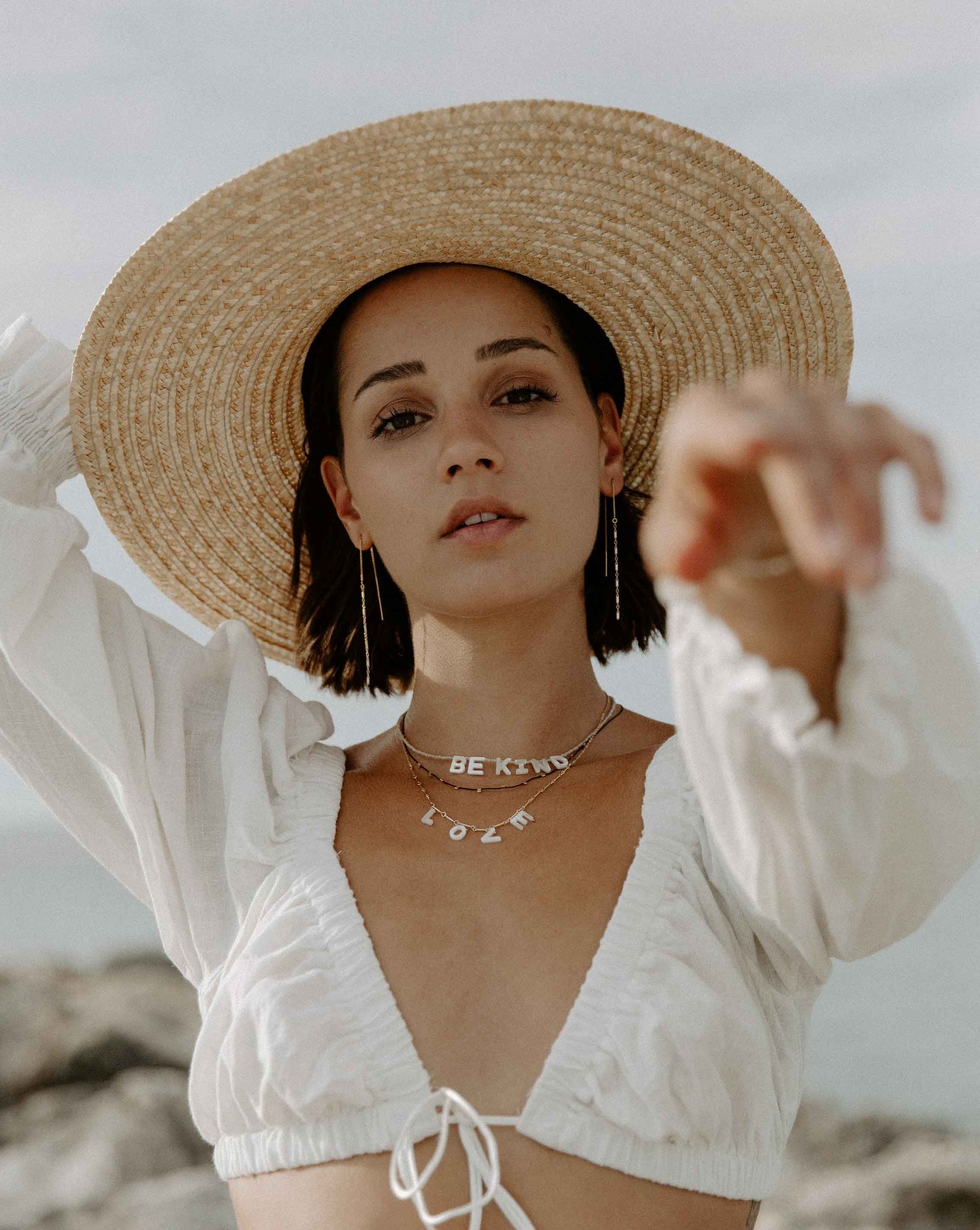 Kind Necklace by KOZAKH. A 16 to 18 inch adjustable length, faceted Zircon beads necklace, crafted with 14K Gold Filled, featuring hand carved Mother of Pearl letters spelling "BE KIND".