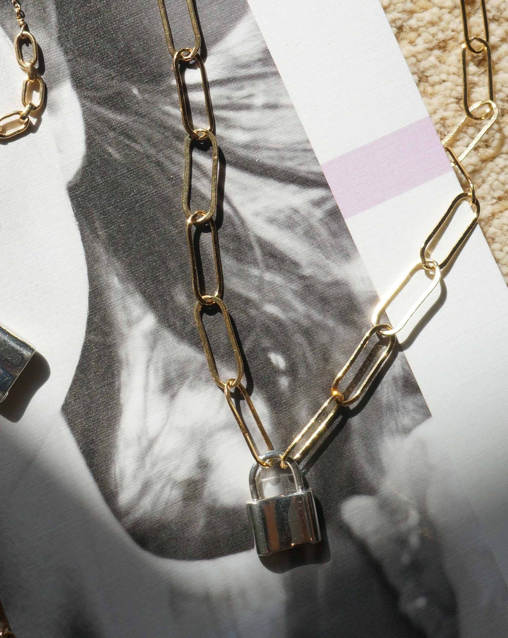 Locklyn Necklace by KOZAKH. A 15 inches long paperclip style chain necklace, crafted in 14K Gold Filled, featuring a Sterling Silver padlock closure.