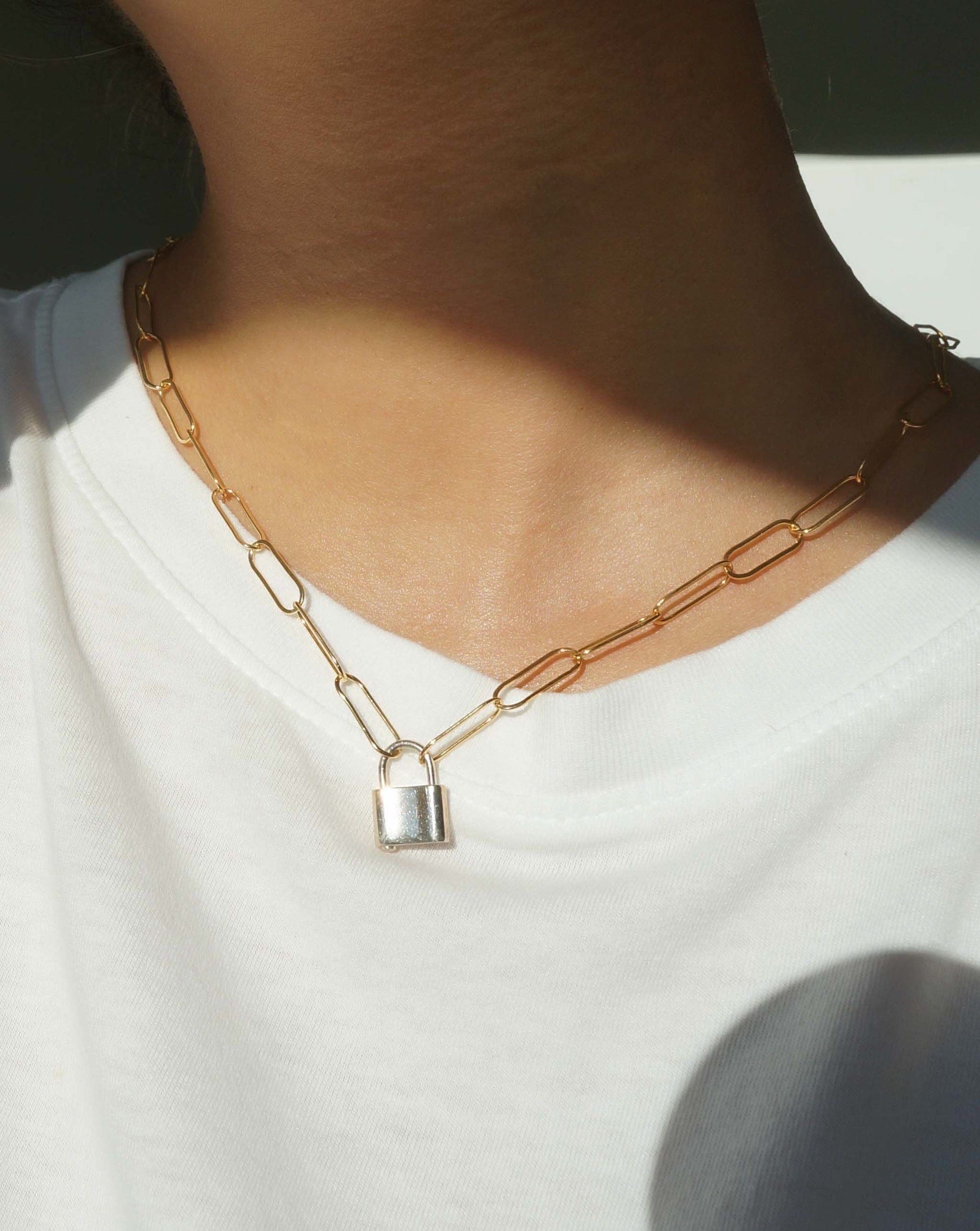 Locklyn Necklace by KOZAKH. A 15 inches long paperclip style chain necklace, crafted in 14K Gold Filled, featuring a Sterling Silver padlock closure.