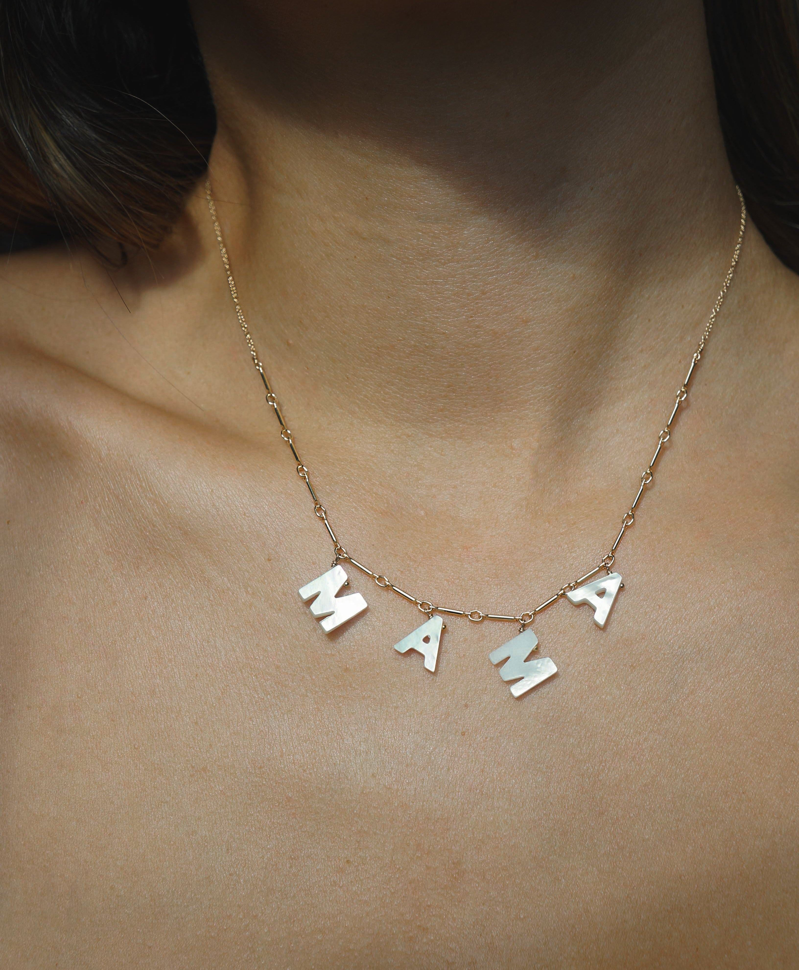 Love Necklace by KOZAKH. A 16 to 18 inch adjustable length necklace with linked bar chain on bottom half and flat link chain on top half, crafted in 14K Gold Filled, featuring a customizable word made from hand carved Mother of Pearl letters.
