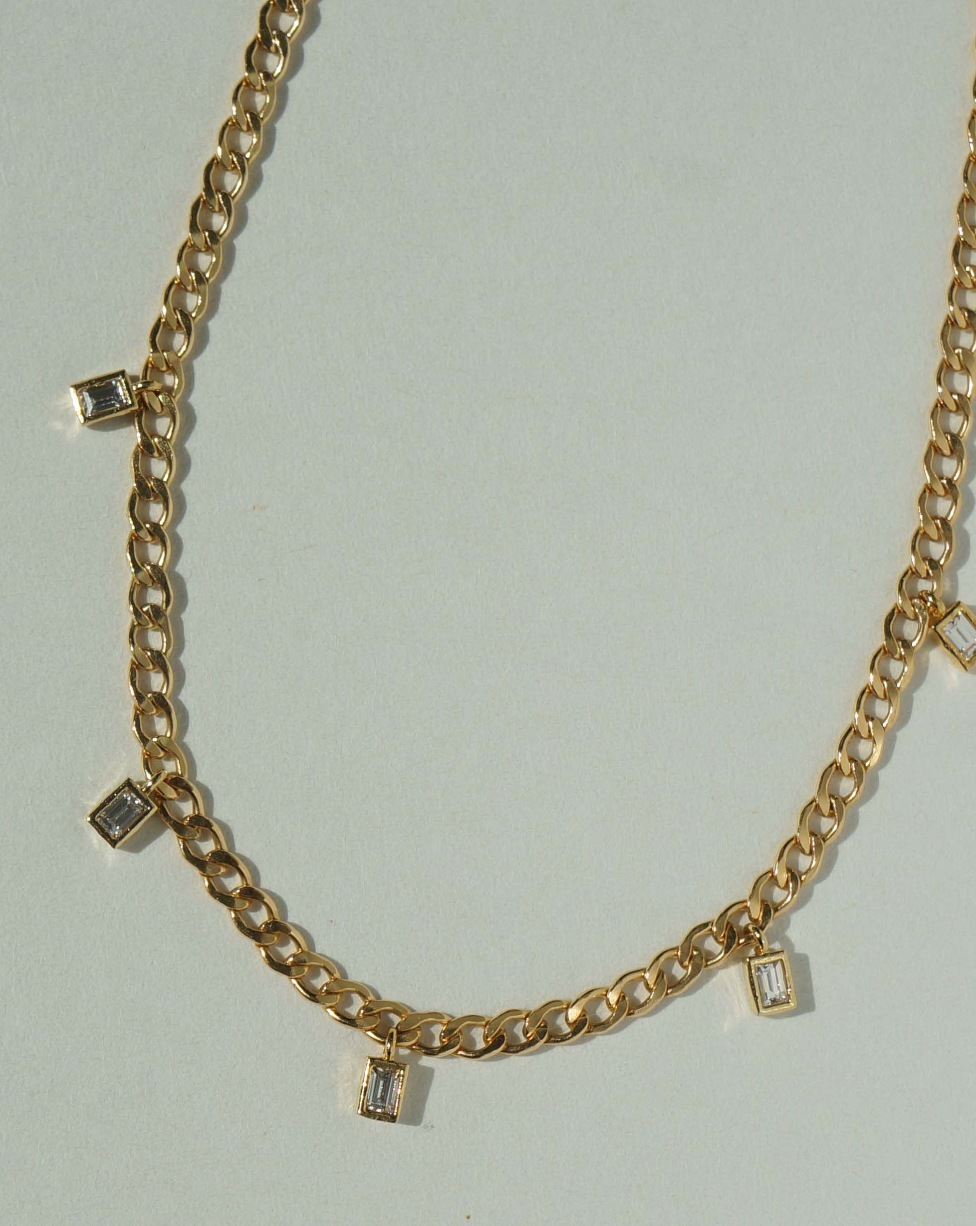 Mia Necklace by KOZAKH. A 16 to 18 inch adjustable length Flat Cuban Link Chain necklace, crafted in 14K Gold Filled, featuring square cut Cubic Zirconia charms.