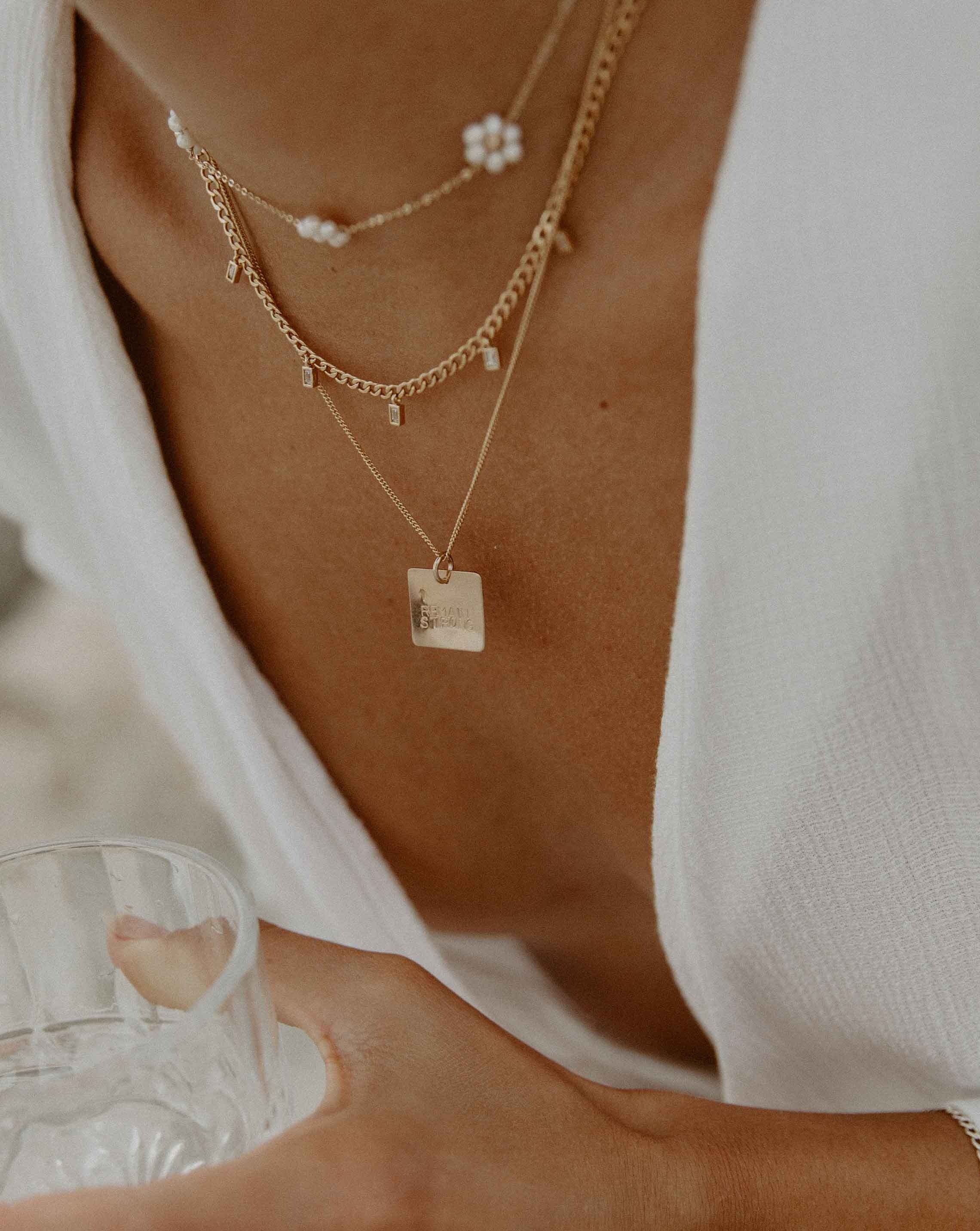 Mia Necklace by KOZAKH. A 16 to 18 inch adjustable length Flat Cuban Link Chain necklace, crafted in 14K Gold Filled, featuring square cut Cubic Zirconia charms.