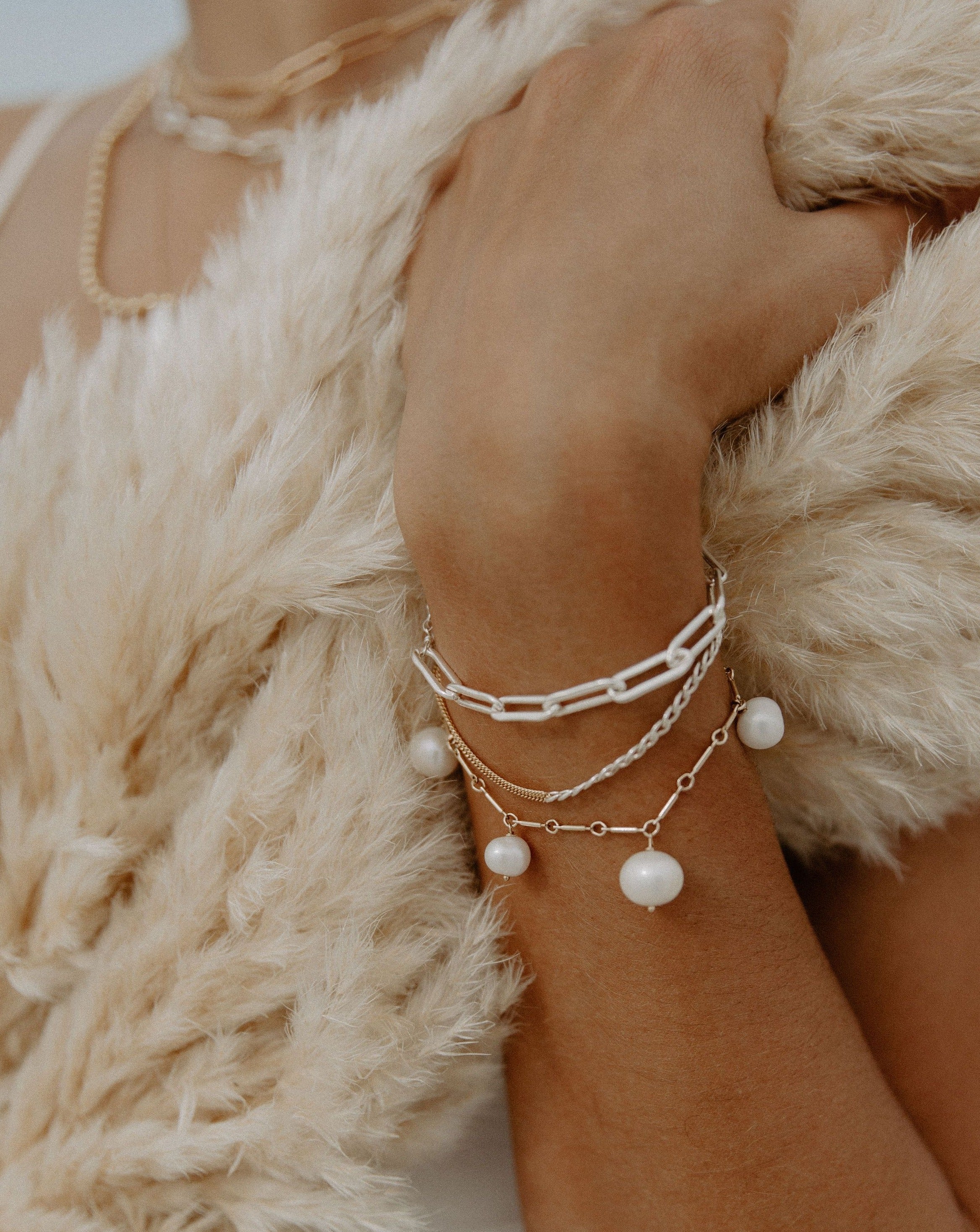 Moni Bracelet by KOZAKH. A 6 to 7 inch adjustable length two tone bracelet with 1mm Gold Filled flat curb chain on one half and 3mm Sterling Silver Cuban link chain on the other half.