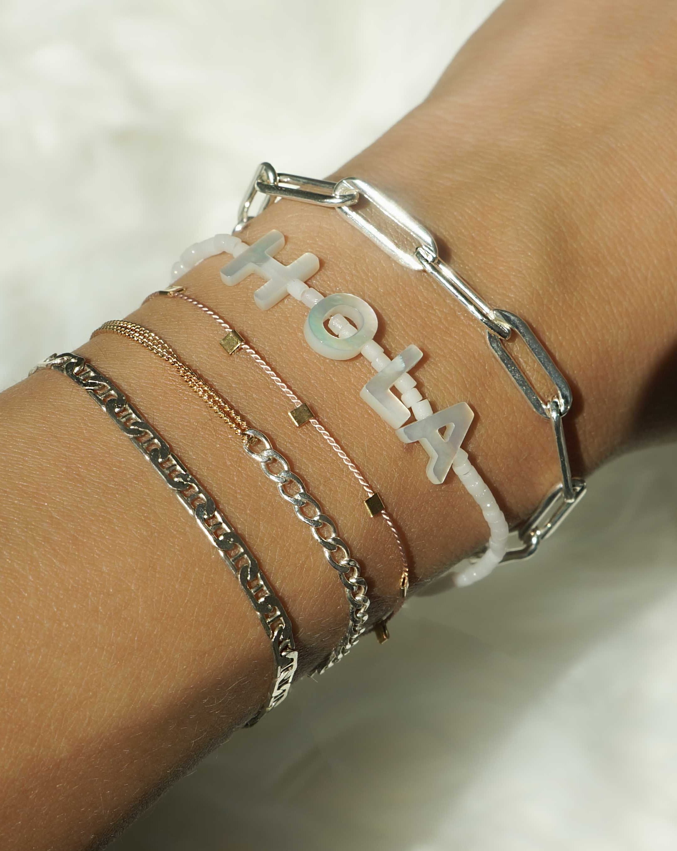 Moni Bracelet by KOZAKH. A 6 to 7 inch adjustable length two tone bracelet with 1mm Gold Filled flat curb chain on one half and 3mm Sterling Silver Cuban link chain on the other half.