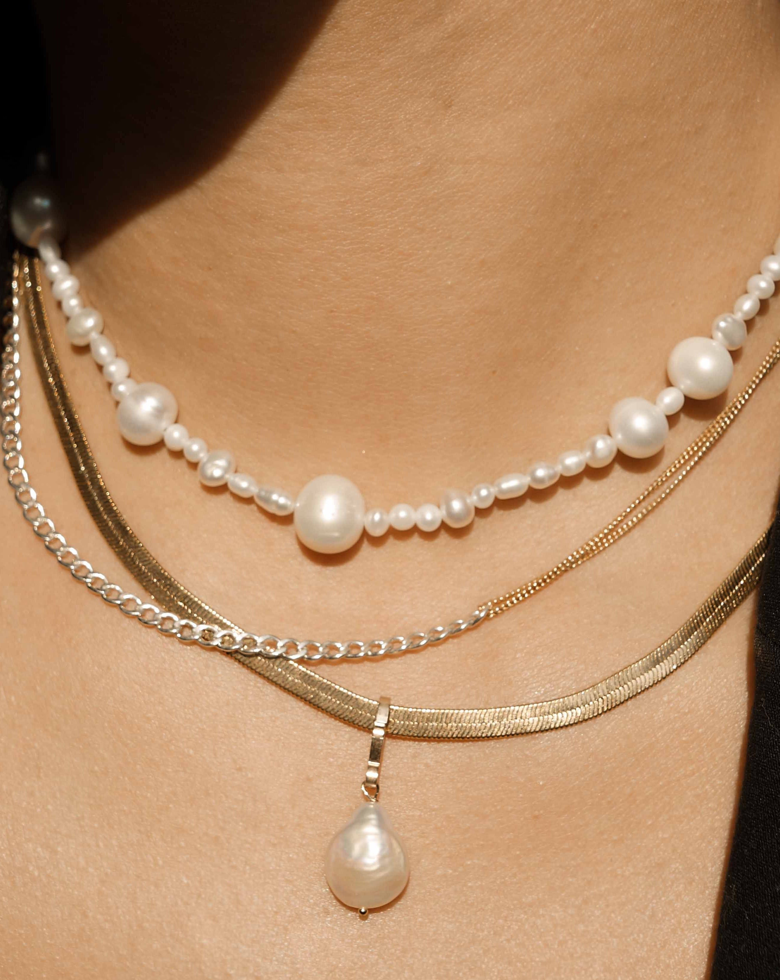 Monica Necklace by KOZAKH. A 14 to 16 inch adjustable length two tone necklace with gold box chain on one half and silver braided chain on the other half.