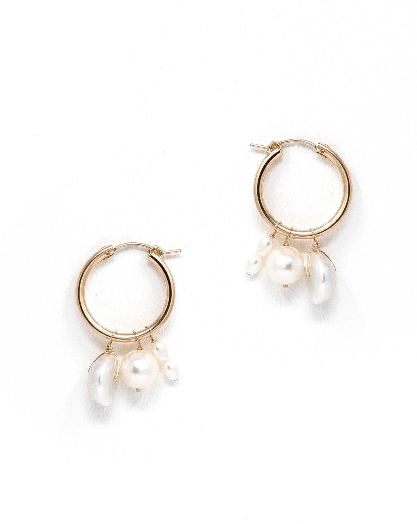 Nadia Hoop Earrings by KOZAKH. 22mm snap closure hoop earrings in 14K Gold Filled, featuring 3-4mm rice Pearls, a 7mm potato Pearl, and a 8mm Keshi Pearl.