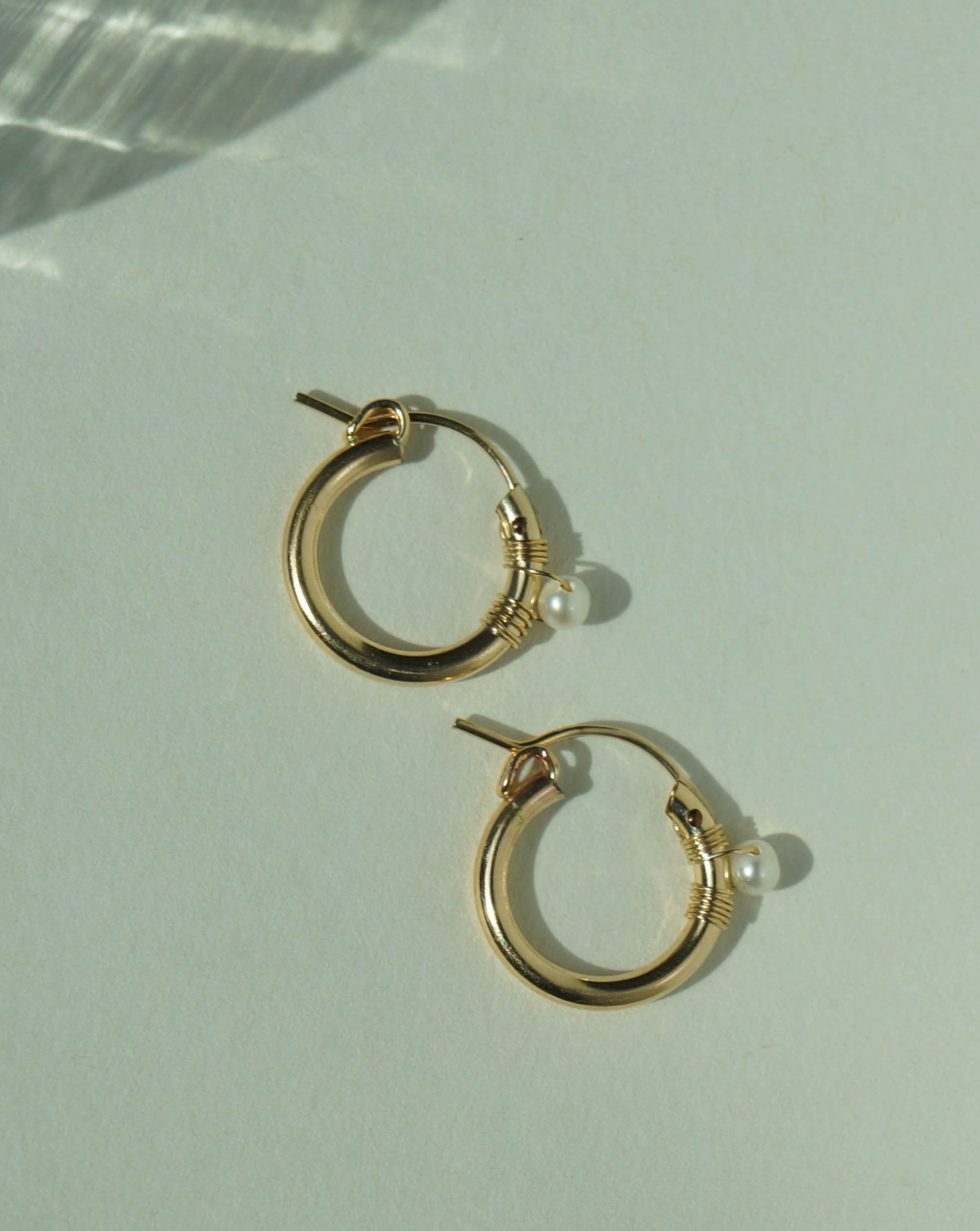 Natalie Earrings by KOZAKH. 12mm snap closure hoop earrings in 14K Gold Filled, featuring a 7mm white potato Pearl.