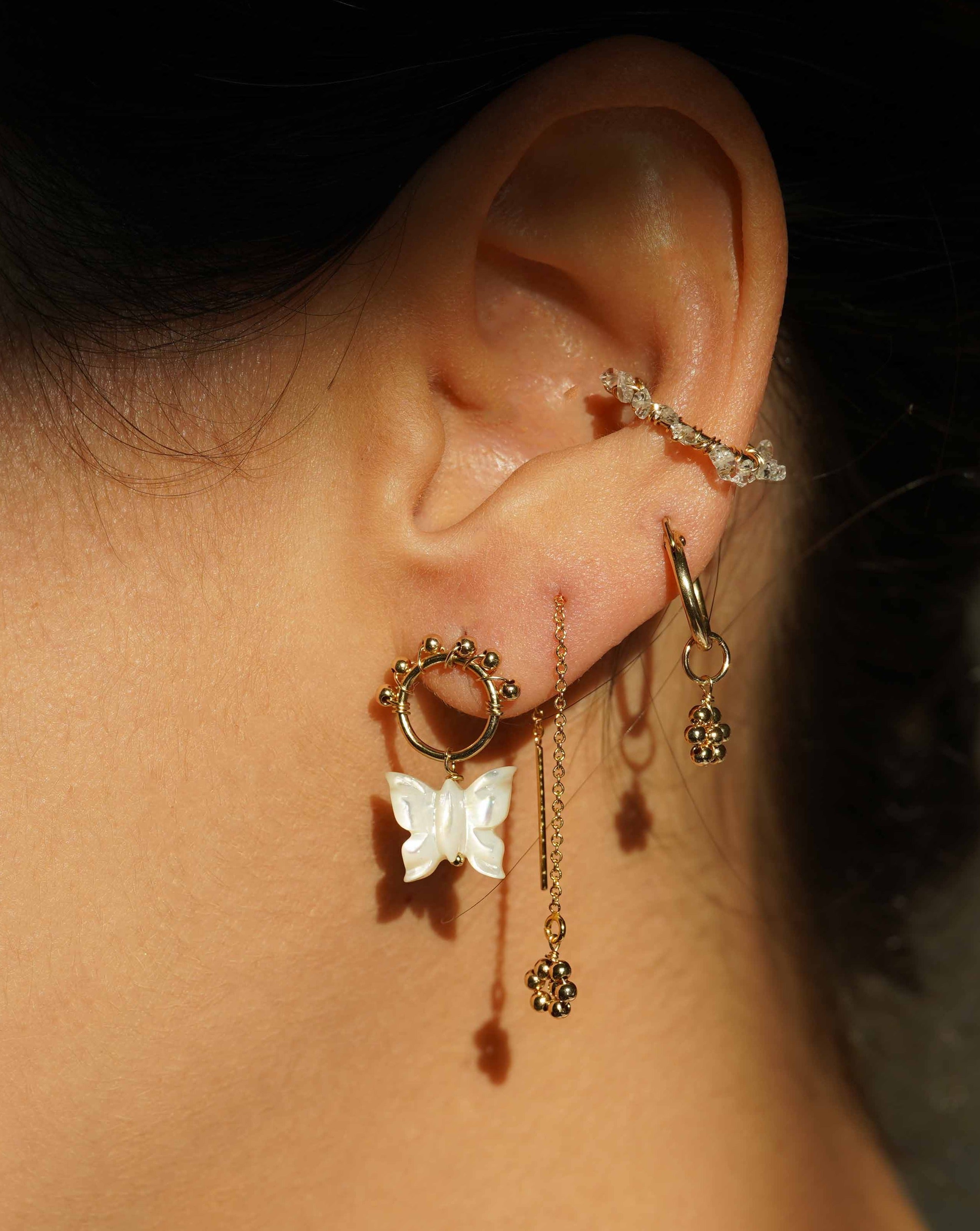 Noor Threader Earrings by KOZAKH. Threader style earrings, crafted in 14K Gold Filled, featuring handmade beaded daisy charms.