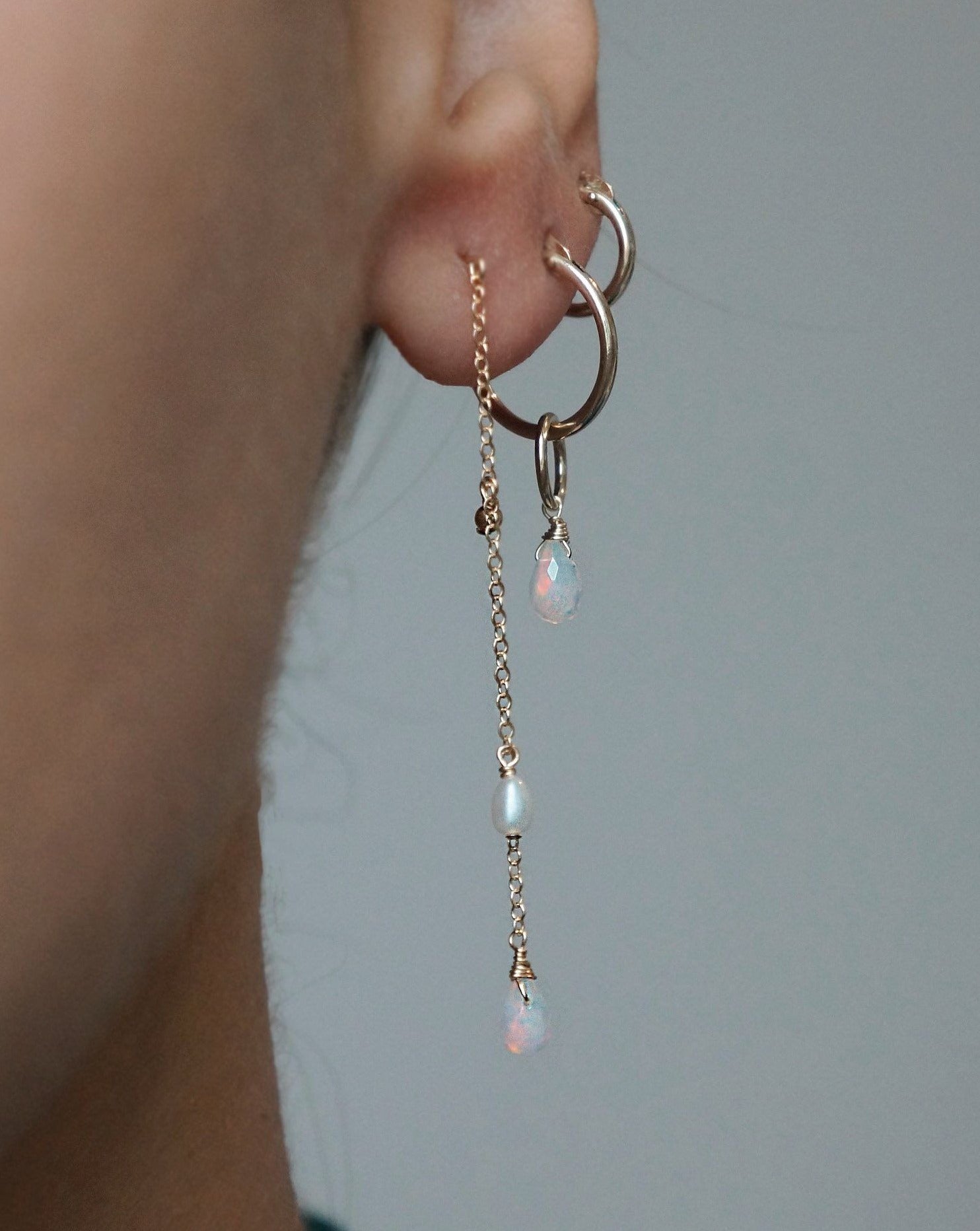 Olivia Earrings by KOZAKH. 15mm snap closure hoop earrings in 14K Gold Filled, featuring a 5mm to 7mm Ethiopian Opal faceted droplet.