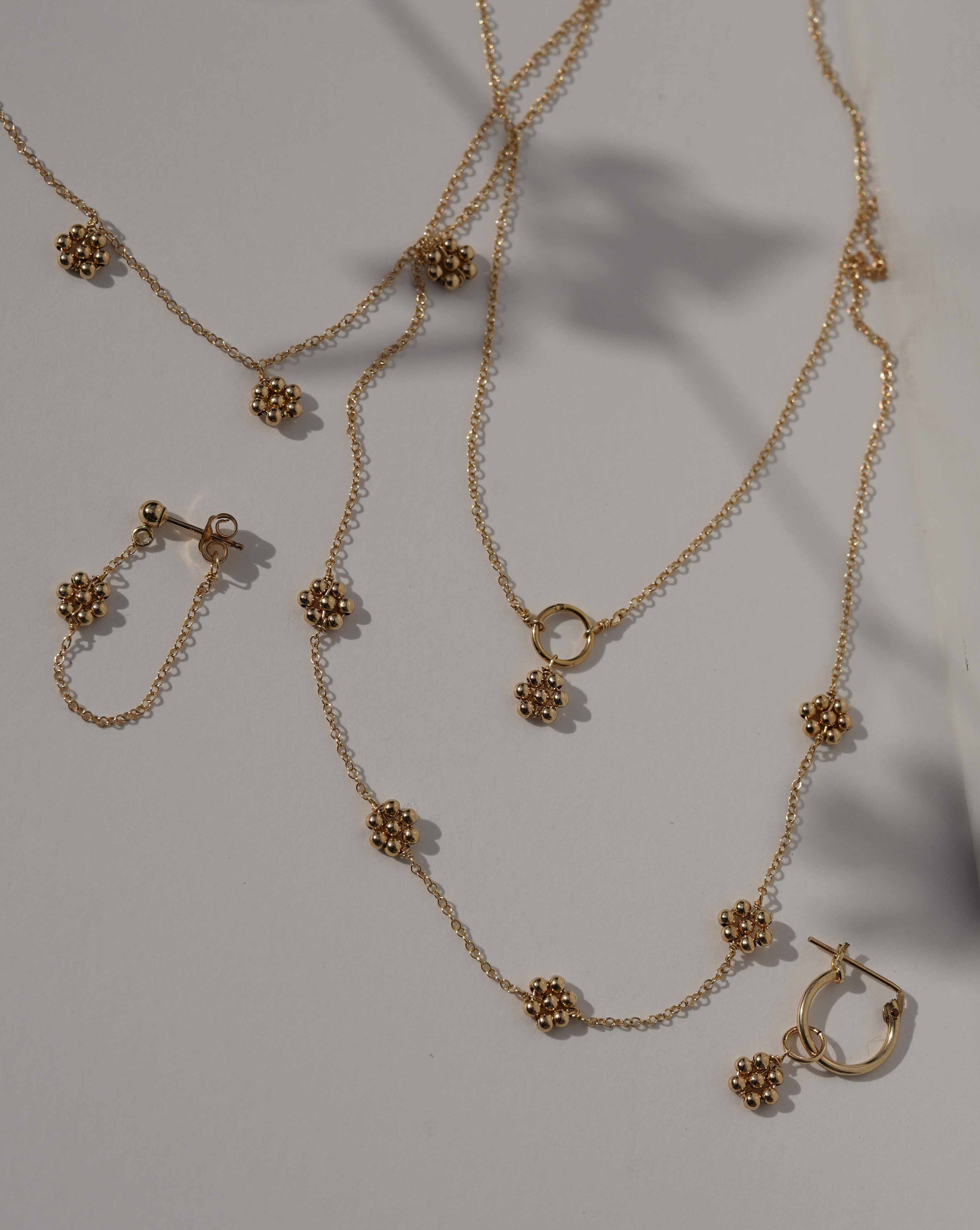 Paloma Necklace by KOZAKH. A 16 to 18 inch adjustable length, 3 inch drop lariat style necklace, crafted in 14K Gold Filled, featuring a handmade beaded daisy charm.