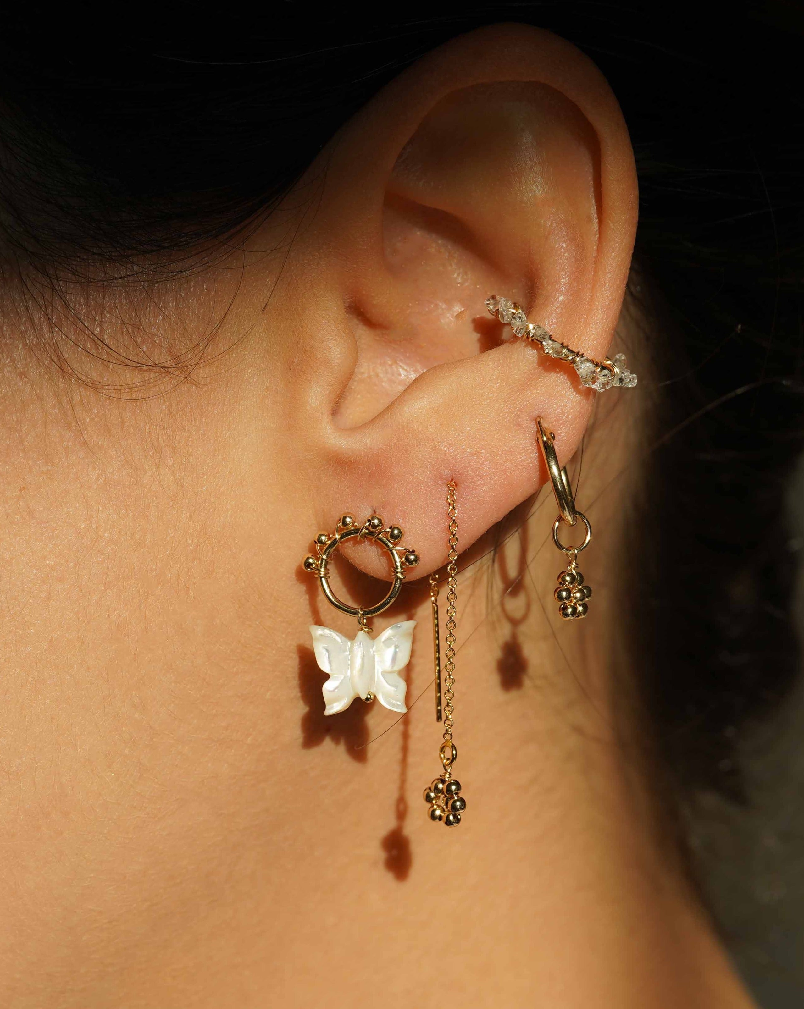 Rosalee Earrings by KOZAKH. 12mm snap closure hoop earrings, crafted in 14K Gold Filled, featuring dangling handmade beaded daisy charms.