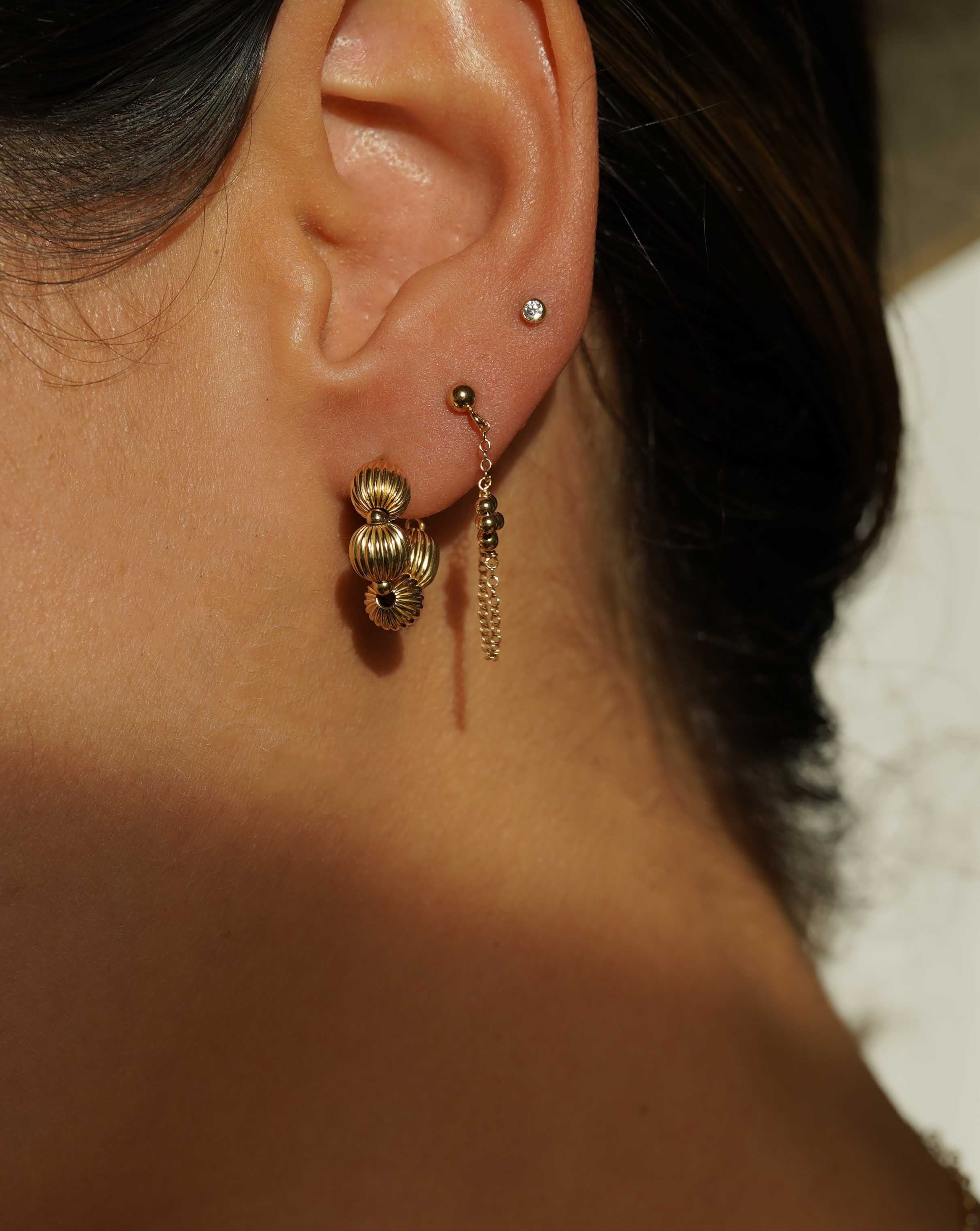 Rosana Earrings by KOZAKH. Front/back style stud closure earrings, crafted in 14K Gold Filled, featuring dangling handmade beaded daisy charms.