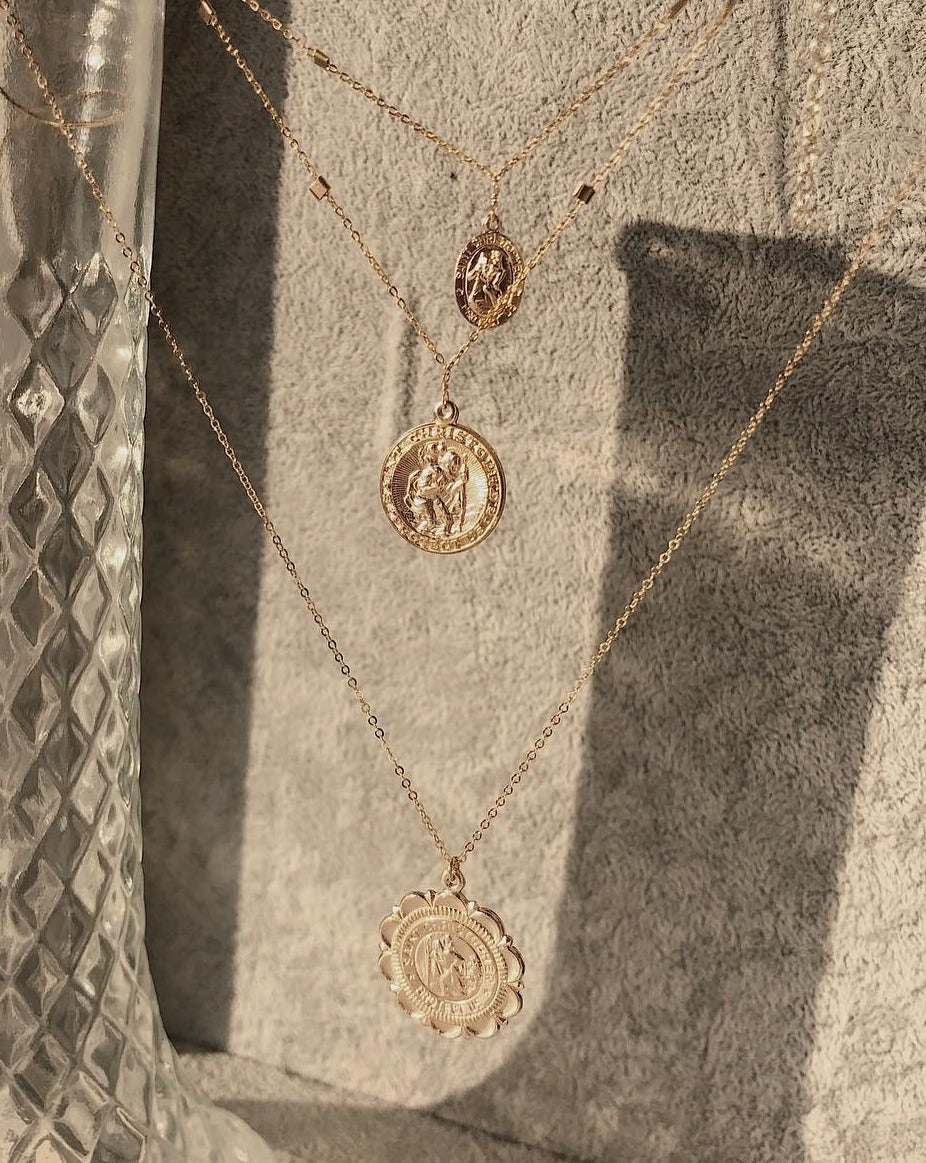 San Cris Long Necklace by KOZAKH. A 20 inches long necklace, crafted in 14K Gold Filled, featuring a 16mm Saint Christopher Medallion.