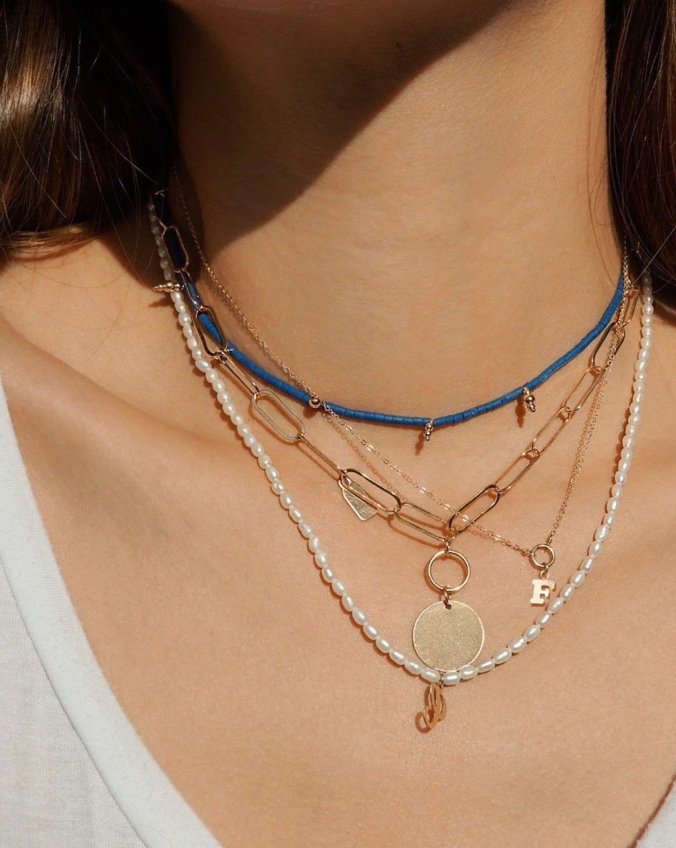 Scarlett Necklace by KOZAKH. A 16 to 18 inch adjustable length, flat oval chain necklace, crafted in 14K Gold Filled, featuring a 3x5mm Tag and a 16mm Flat coin.