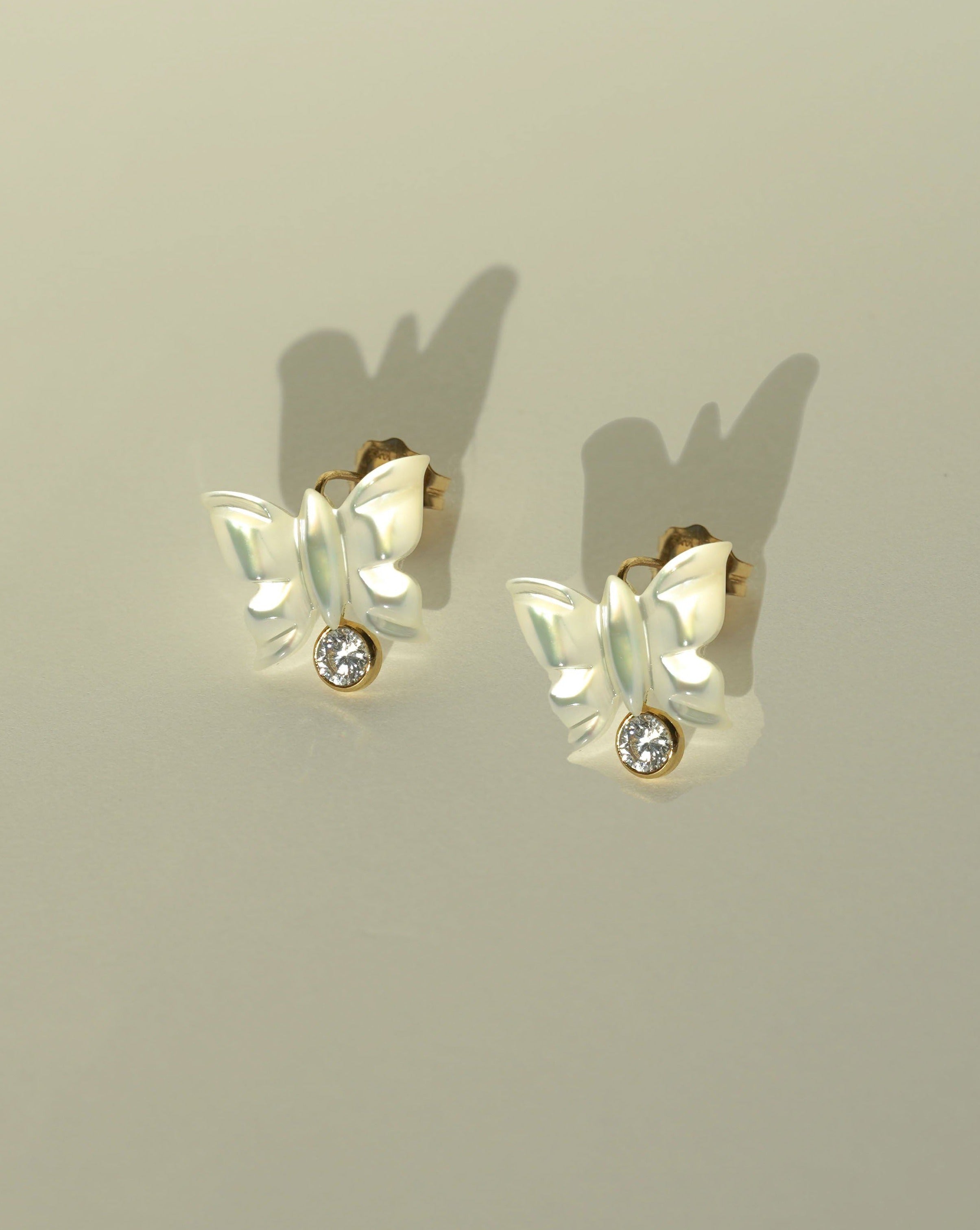 Sevyn Earrings by KOZAKH. Stud earrings, crafted in 14K Gold Filled, featuring a hand carved butterfly charm and a bezel set Cubic Zirconia.