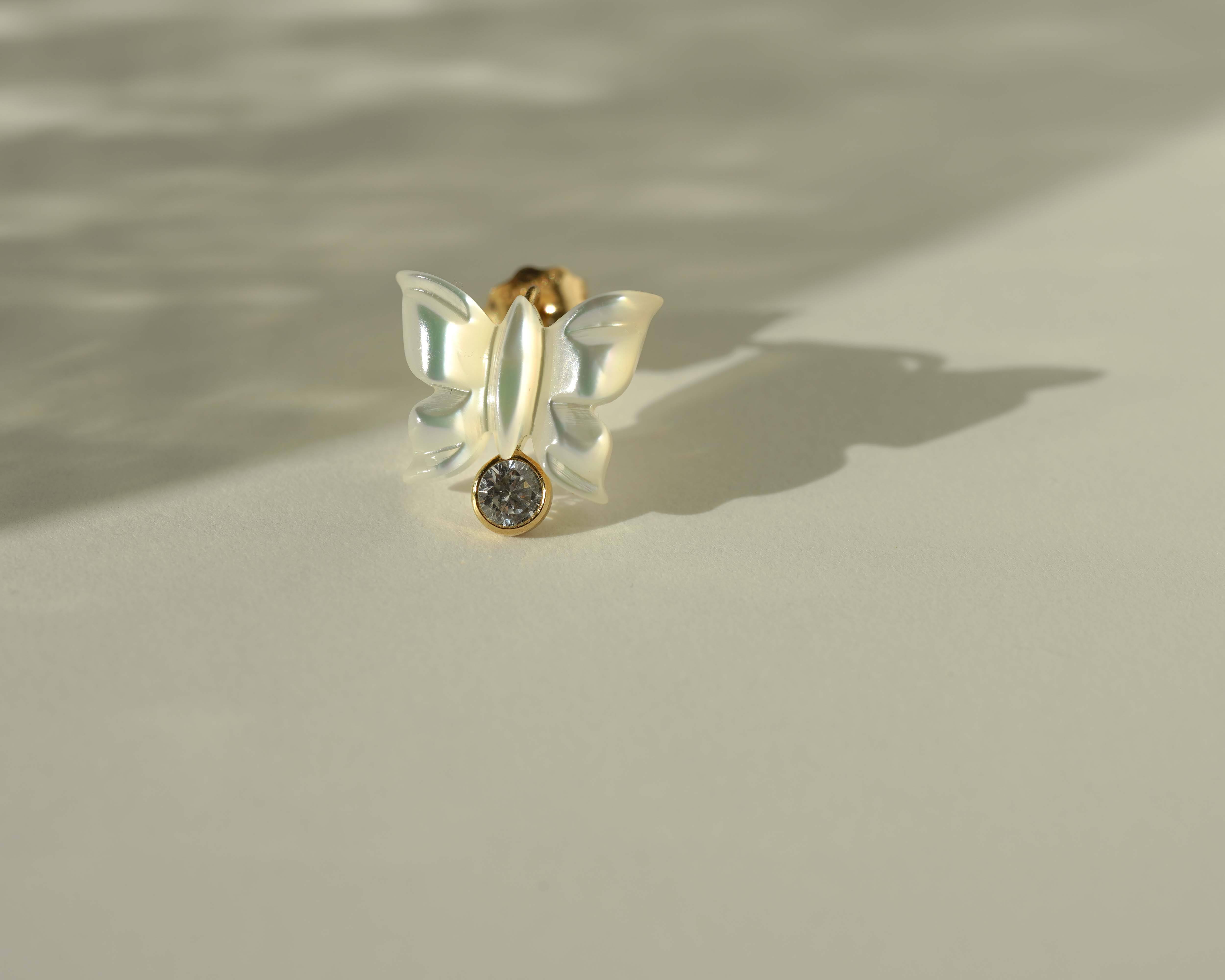 Sevyn Earrings by KOZAKH. Stud earrings, crafted in 14K Gold Filled, featuring a hand carved butterfly charm and a bezel set Cubic Zirconia.