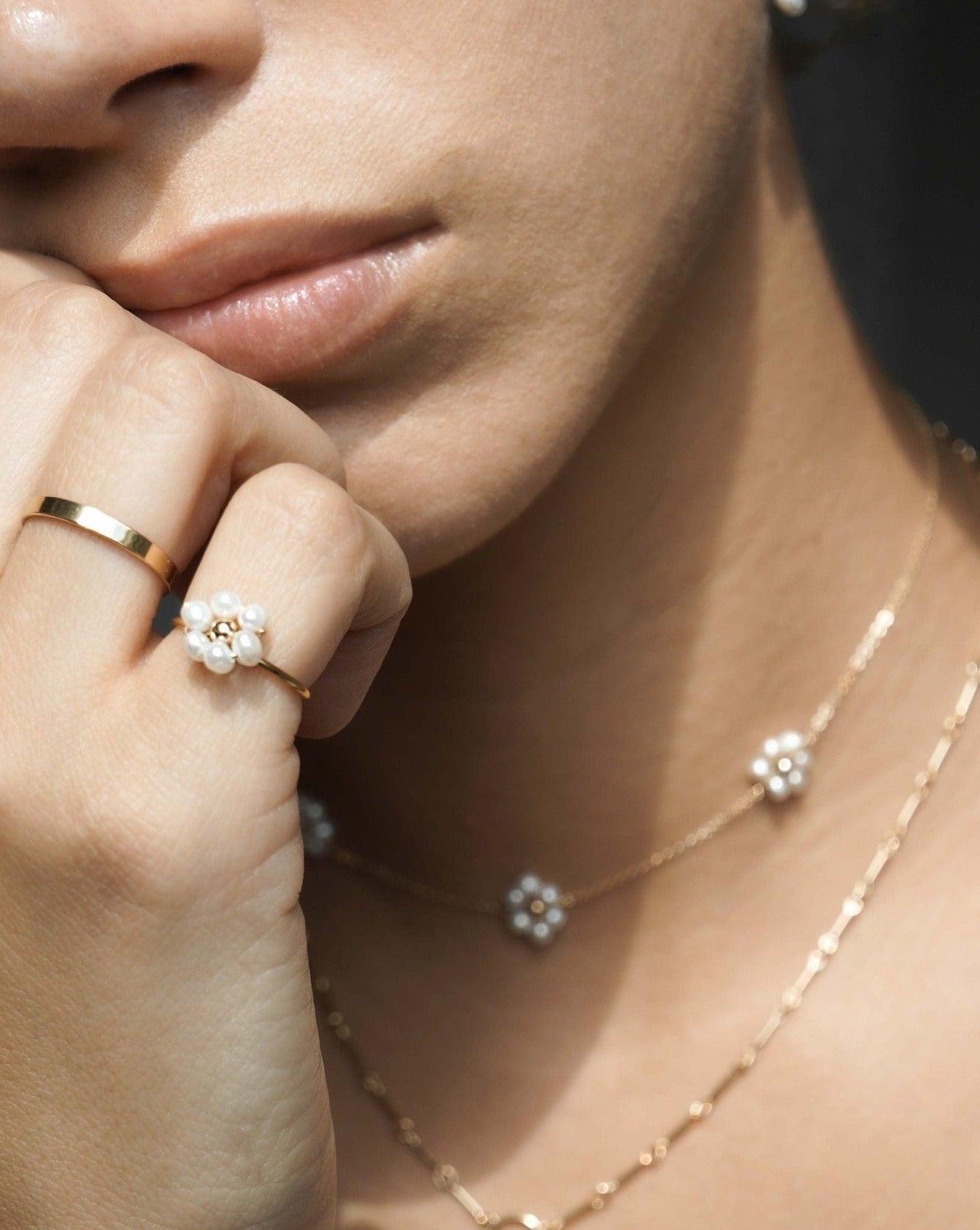 Sun Ring by KOZAKH. A 1mm round ring, crafted in 14K Gold Filled, featuring white freshwater Pearls and a gold bead forming a handmade daisy charm.