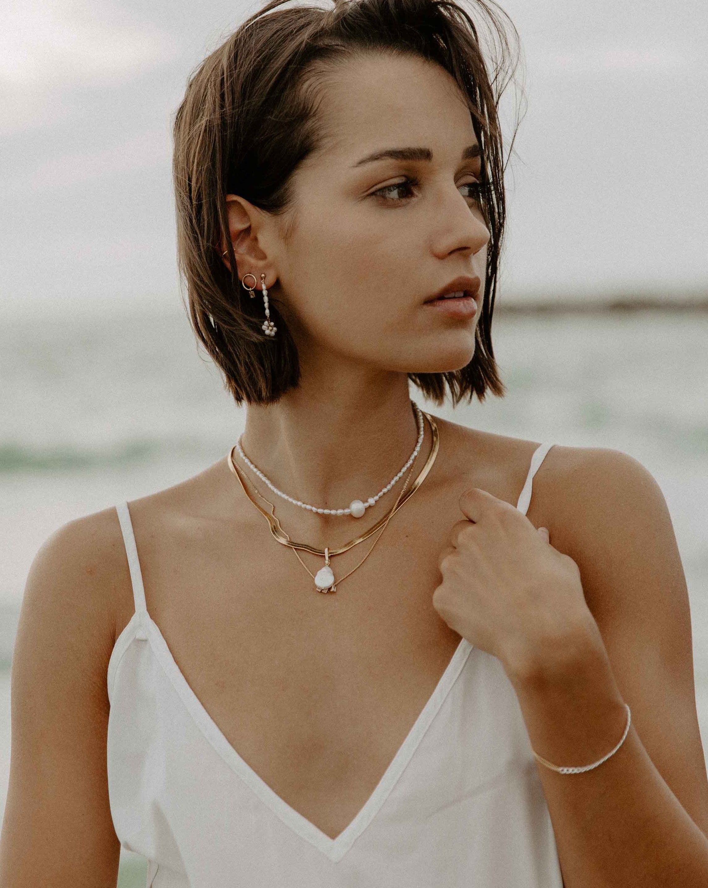 Sunflower Earrings by KOZAKH. 3mm Ball stud drop earrings with 2 inches drop length, crafted in 14K Gold Filled, featuring 3mm rice freshwater Pearls and 3-4mm round freshwater Pearls forming a flower charm.