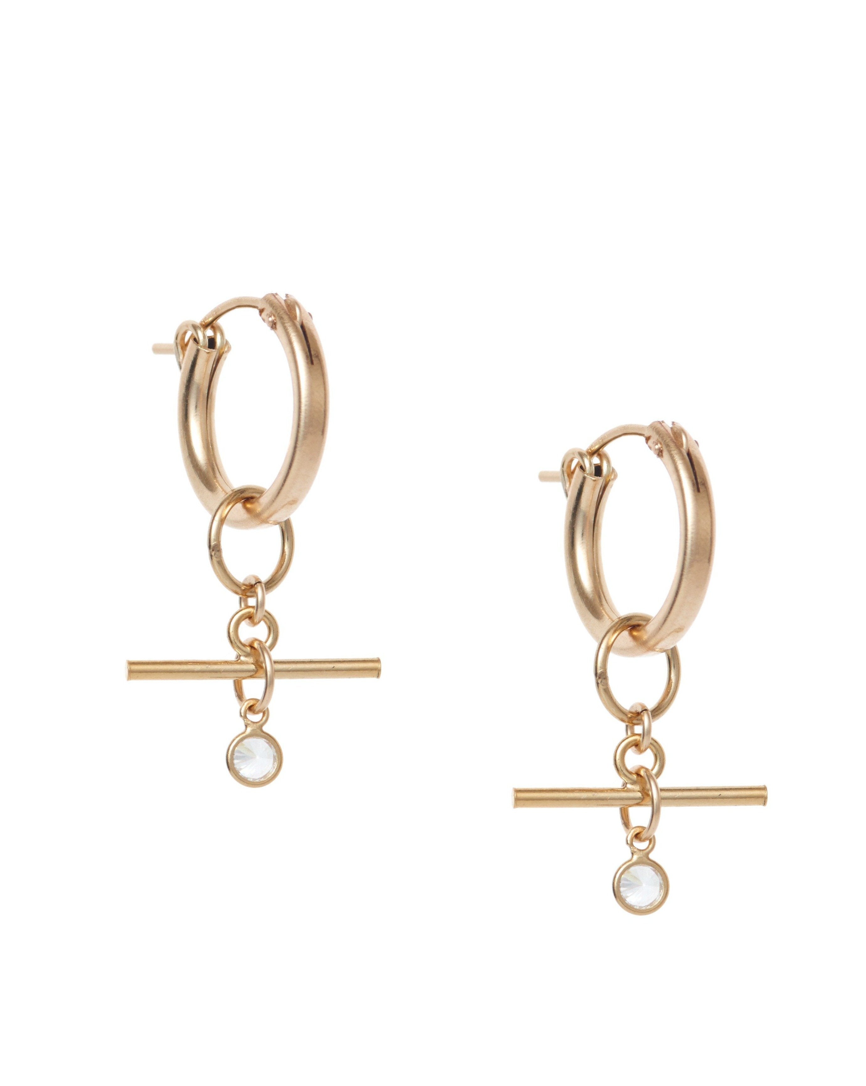 Tanya Earrings by KOZAKH. 15mm snap closure hoop earrings, crafted in 14K Gold Filled, featuring a dangling horizontal bar and a 3mm Cubic Zirconia Bezel.