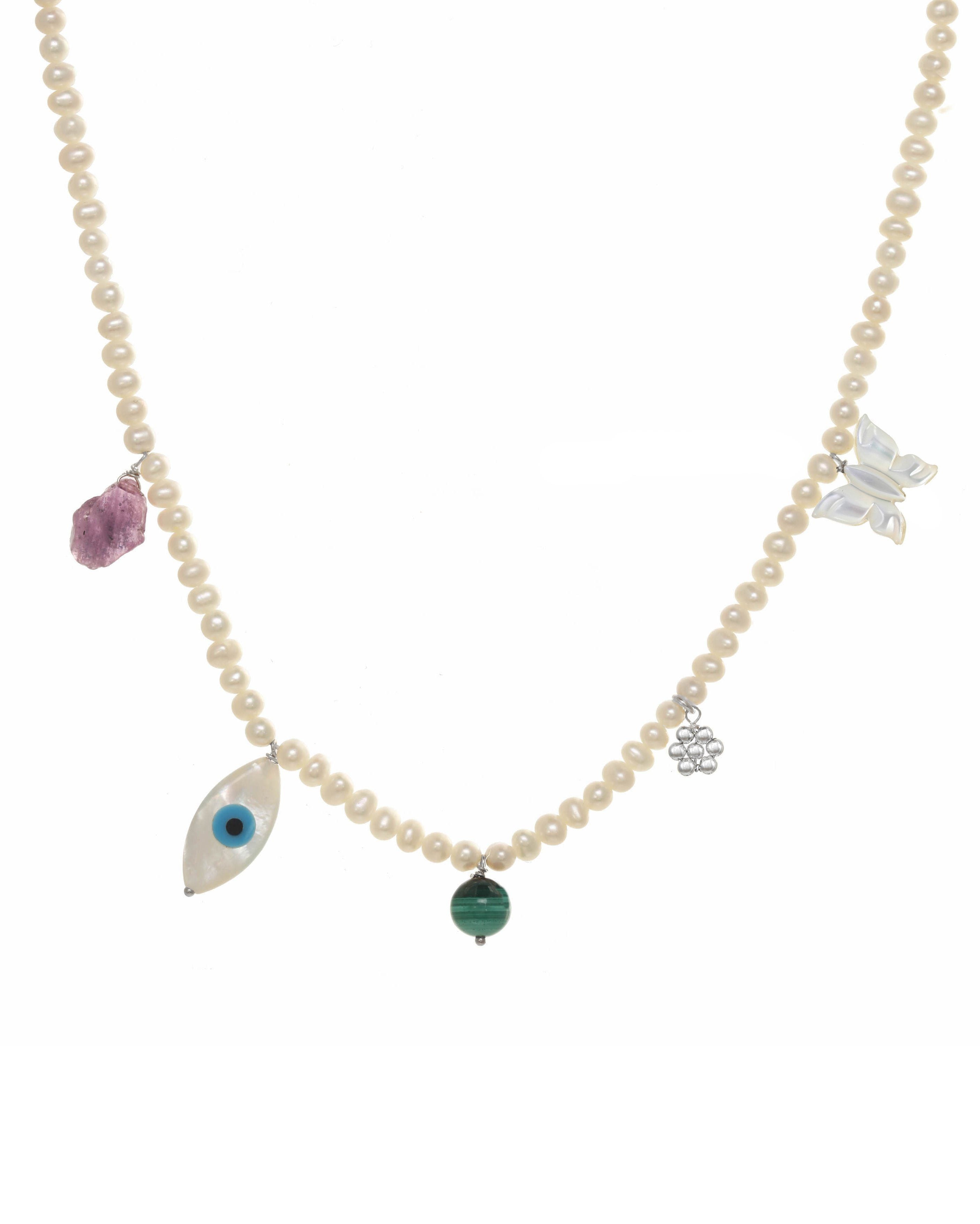 Valery Necklace by KOZAKH. A 16 to 18 inch adjustable length necklace, with 16 inch strand of 3mm Freshwater Pearls, clasp crafted in Sterling Silver, featuring Pink Tourmaline slice, Mother of Pearl butterfly charm, smooth round Malachite gemstone, Mother of Pearl eye charm, and handmade silver beaded daisy charm.