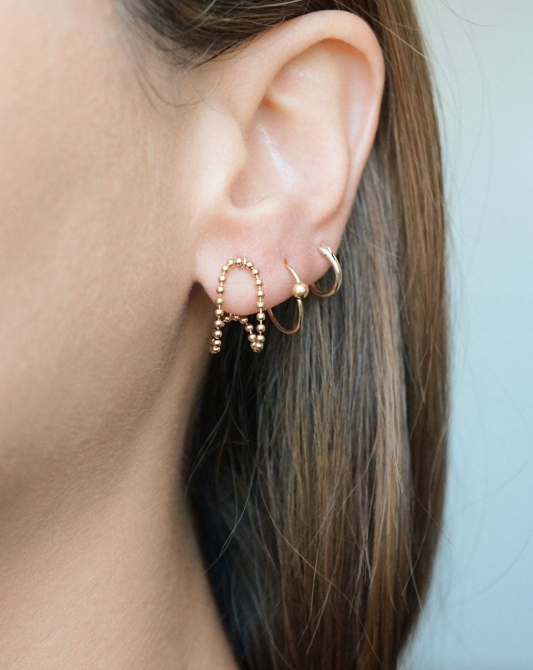Venla Huggie Earrings by KOZAKH. Stud earrings, crafted in 14K Gold Filled, featuring a strand of 1mm seamless beads.