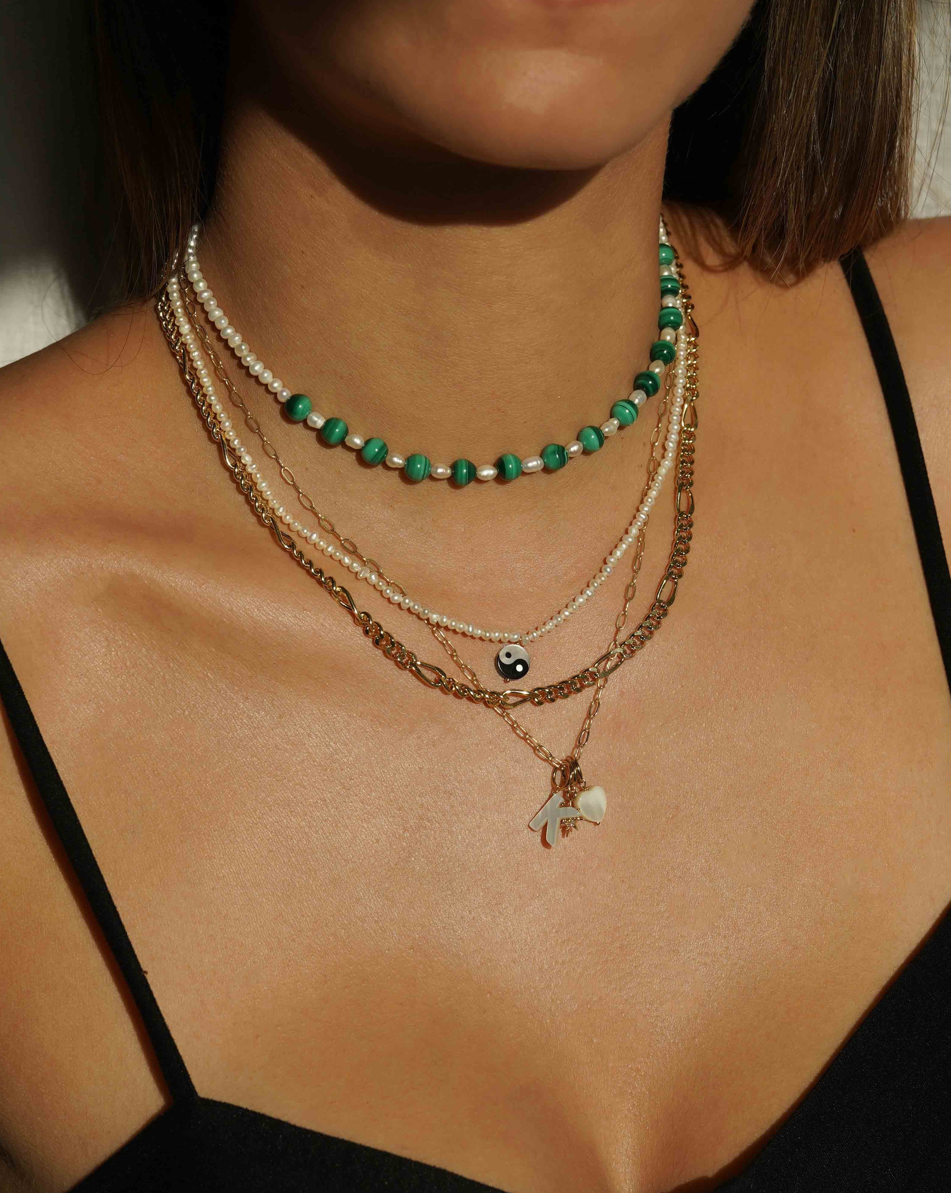 Yin Yang Pearl Necklace by KOZAKH. A 16 to 18 inch adjustable length necklace, with 16 inch strand of 3.5mm Freshwater Pearls, clasp crafted in 14K Gold Filled, featuring a hand carved Mother of pearl Yin Yang charm.