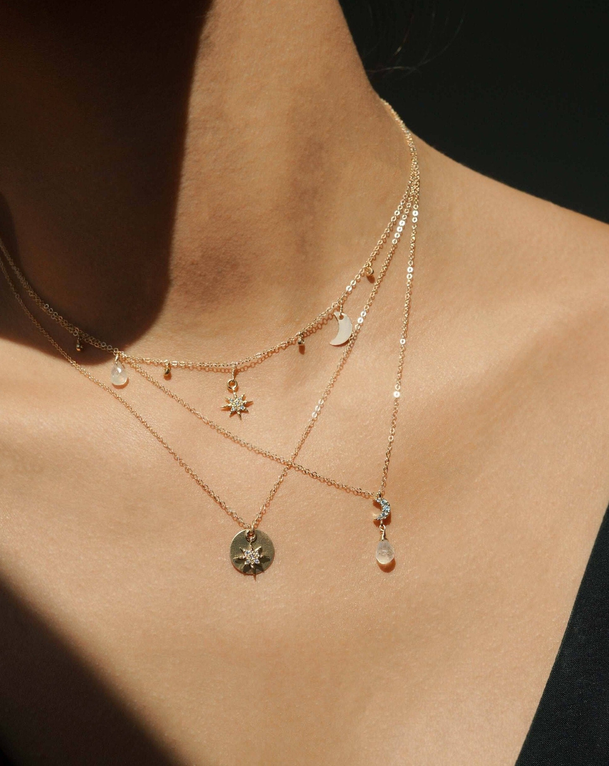 Adeena Necklace by KOZAKH. A 16 to 18 inch adjustable length necklace in 14K Gold Filled, featuring a coin charm and a Cubic Zirconia star charm.