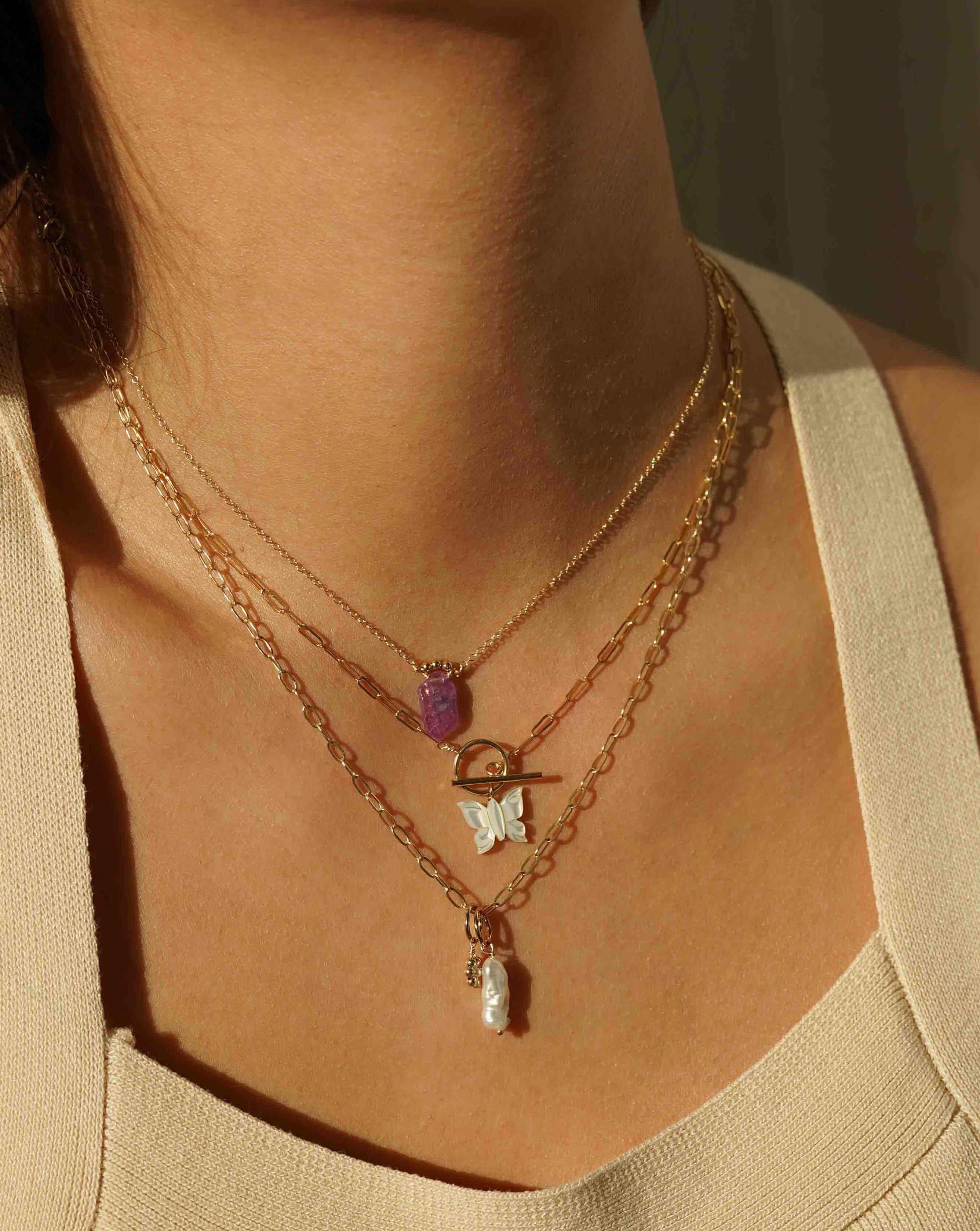 Arlette Necklace by KOZAKH. A 16 to 18 inch adjustable length necklace in 14K Gold Filled, featuring a hand-carved Mother of Pearl butterfly charm and a toggle closure at front of the necklace.